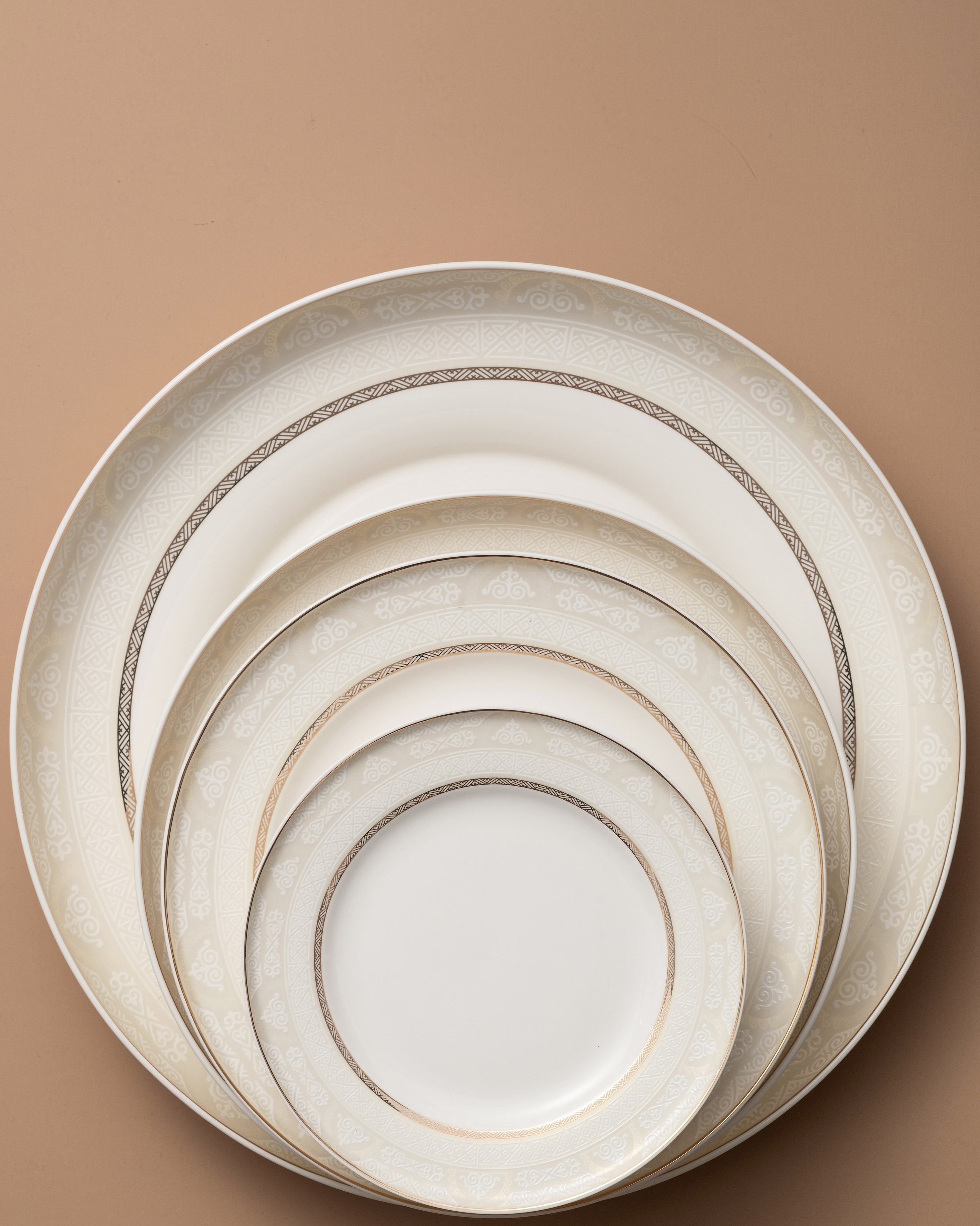 Минималистичный комплект тарелок с текстурой под кожу на коричневом фоне