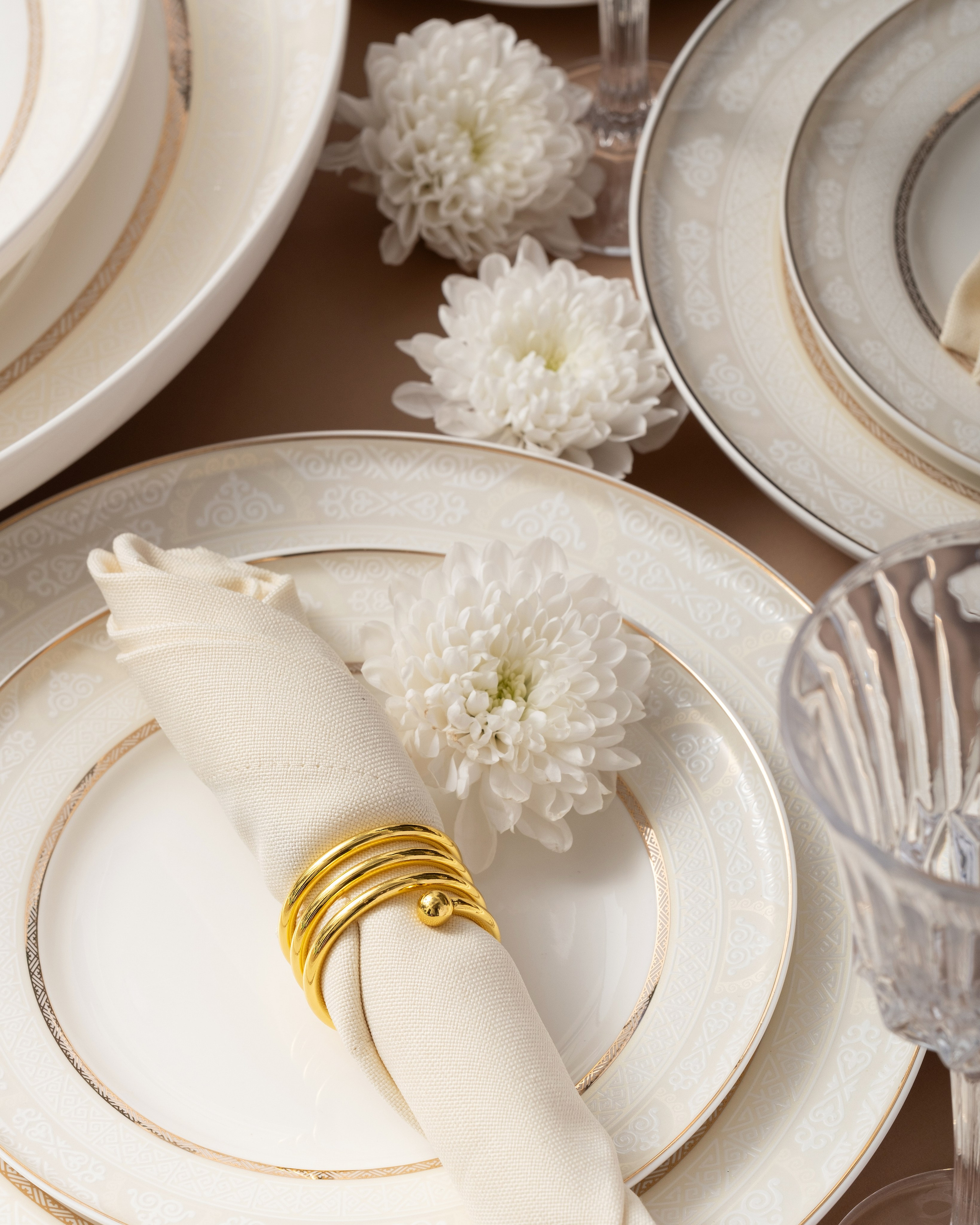 Светлая волнистая посуда с золотым кантом на фоне сирени и фиолетового цвета