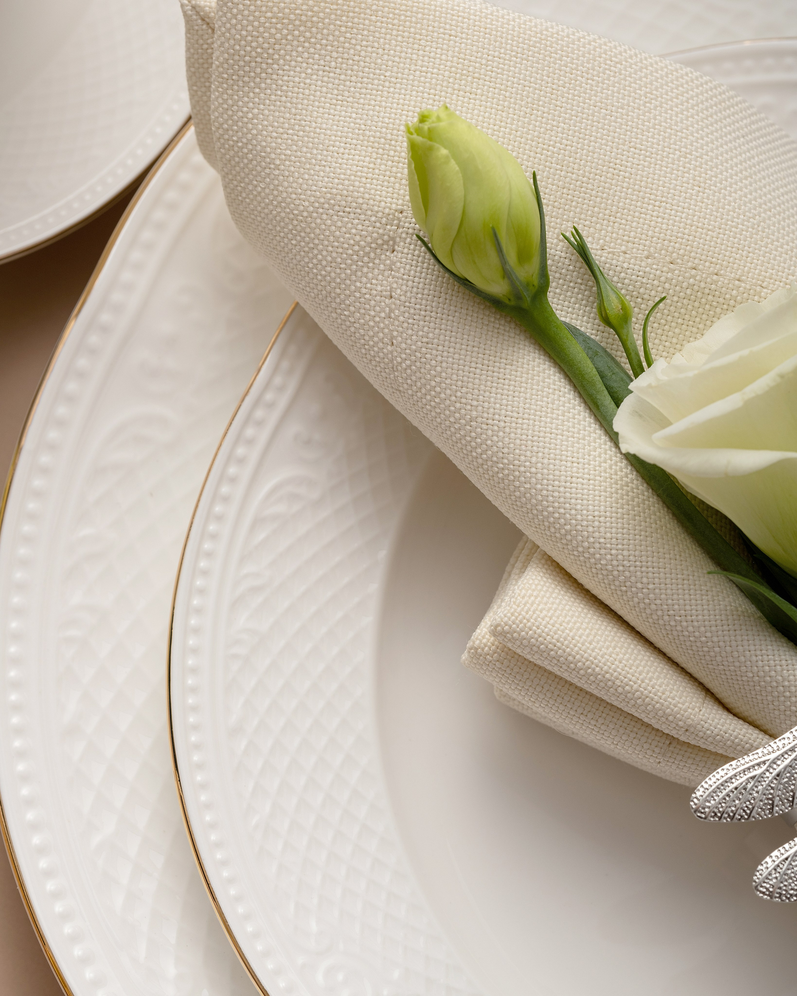 Предметная фотосъёмка сервировки: белая тарелка с золотым кантом, бежевая салфетка и белая роза — пример фирменного визуального стиля WASEELA