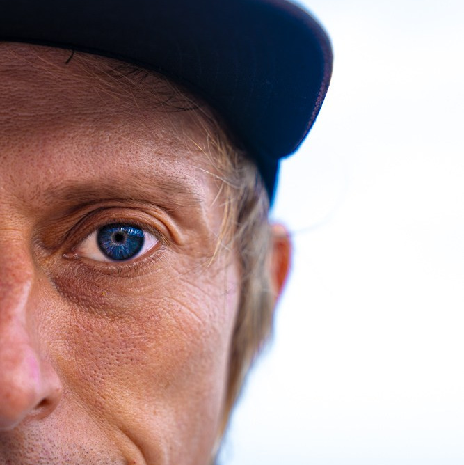 Портрет фотографа Kartashow (Кaрташов), синие глаза, бейсболка. Для страницы контактов.