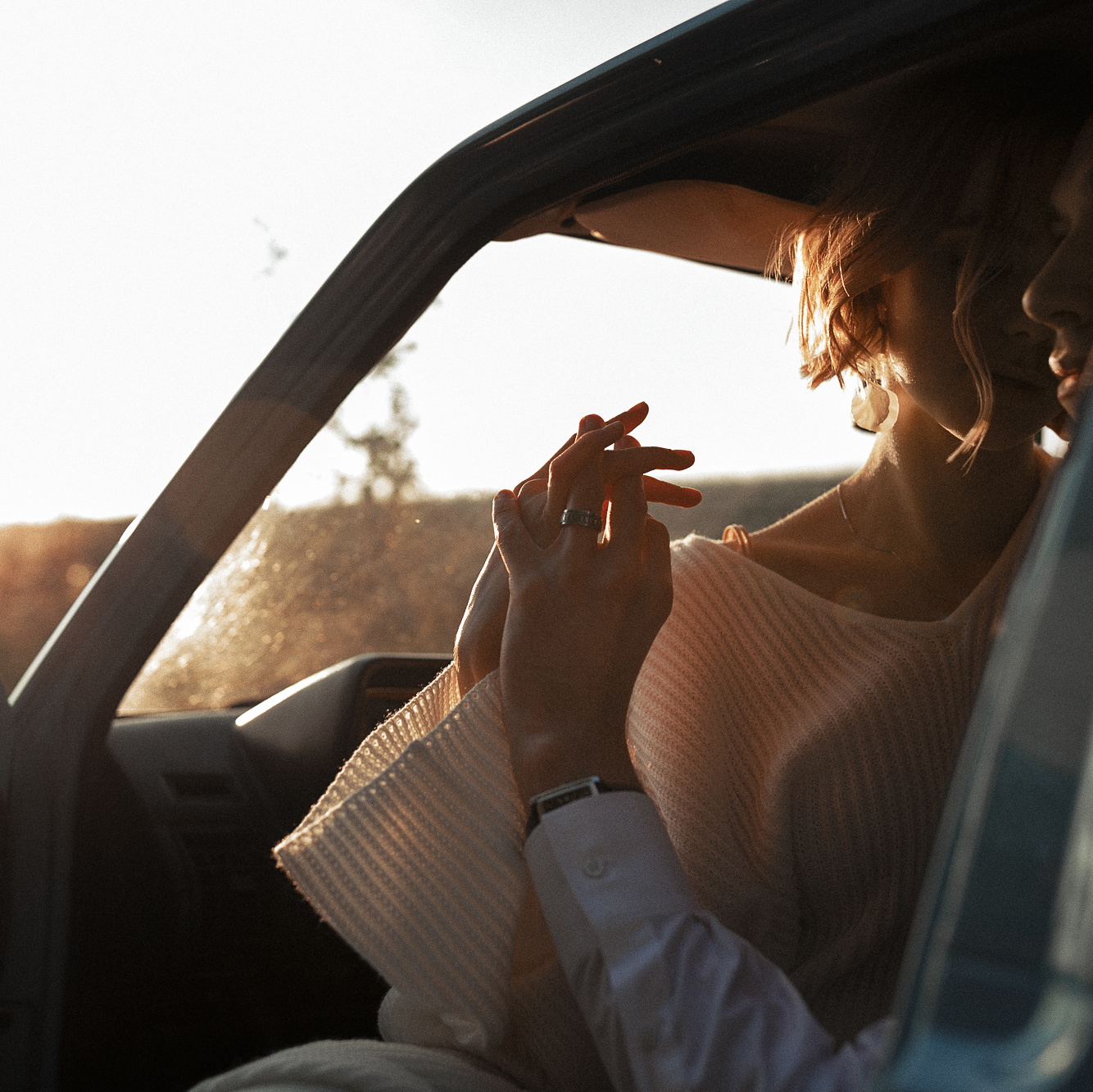 Нежные поцелуи новобрачных в лучах заходящего солнца. 