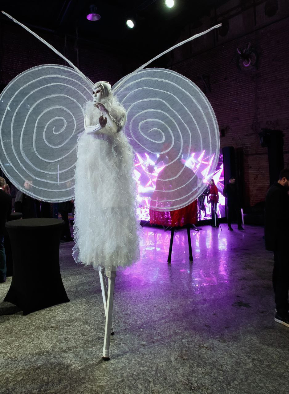 Ходулист белая Бабочка встречает гостей в большом зале ЛОФТ ХОЛЛ в Москве.