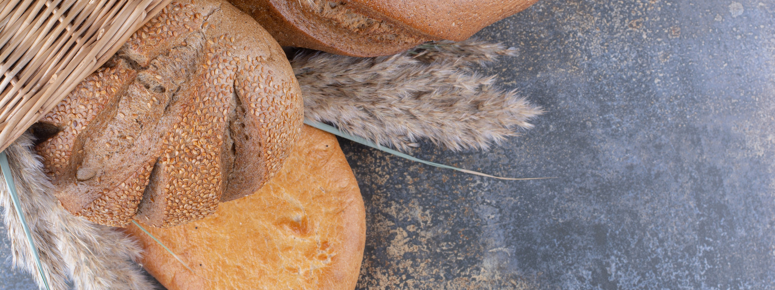 Красивые хлеба, пшеничные и ржаные сорта в плетеной корзине