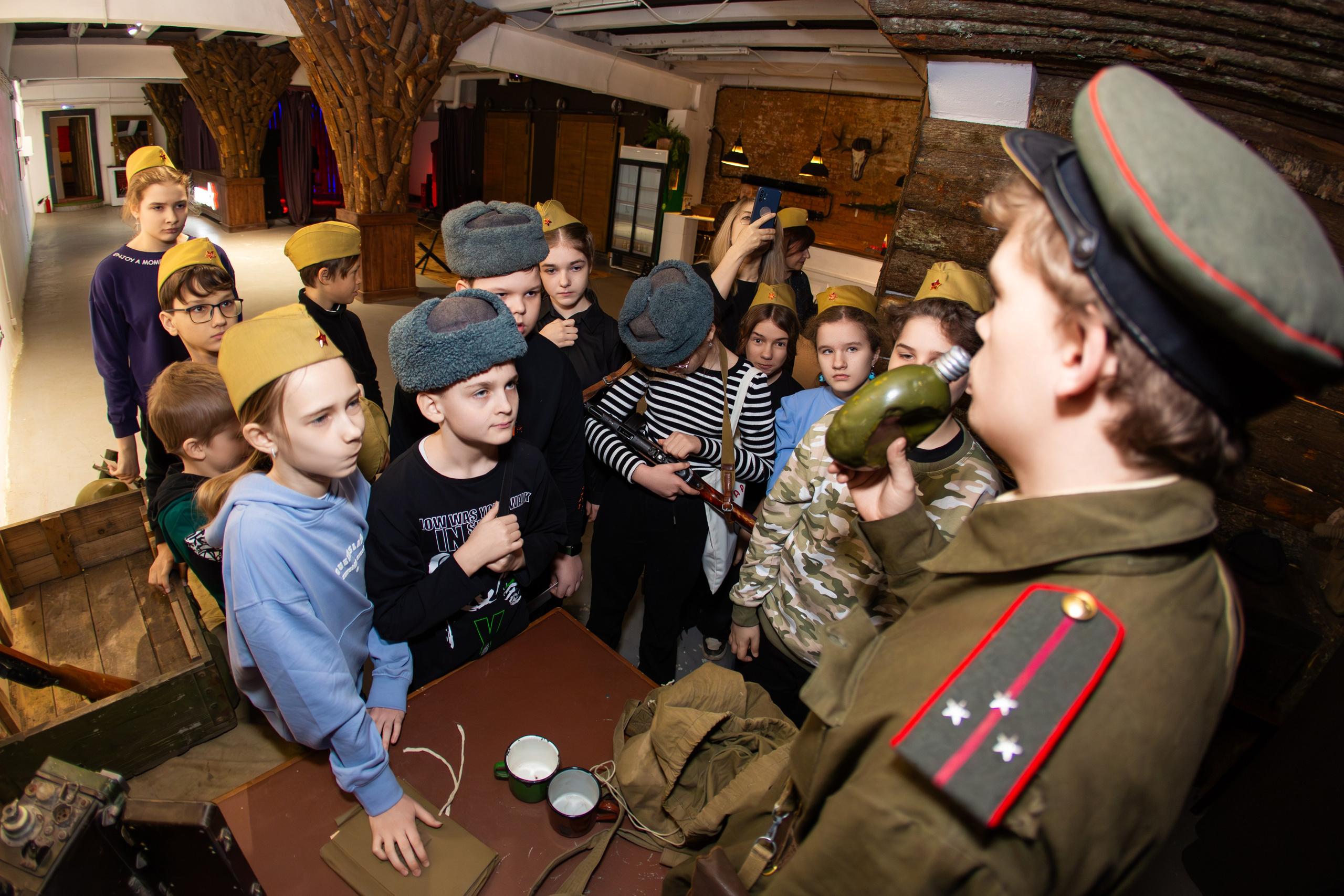 Группа школьников в пилотках слушает экскурсовода в военной форме на интерактивной экскурсии 'Лето 43' в Орле, фото событийной фотосъёмки фотографа Орёл Николая Богатырёва