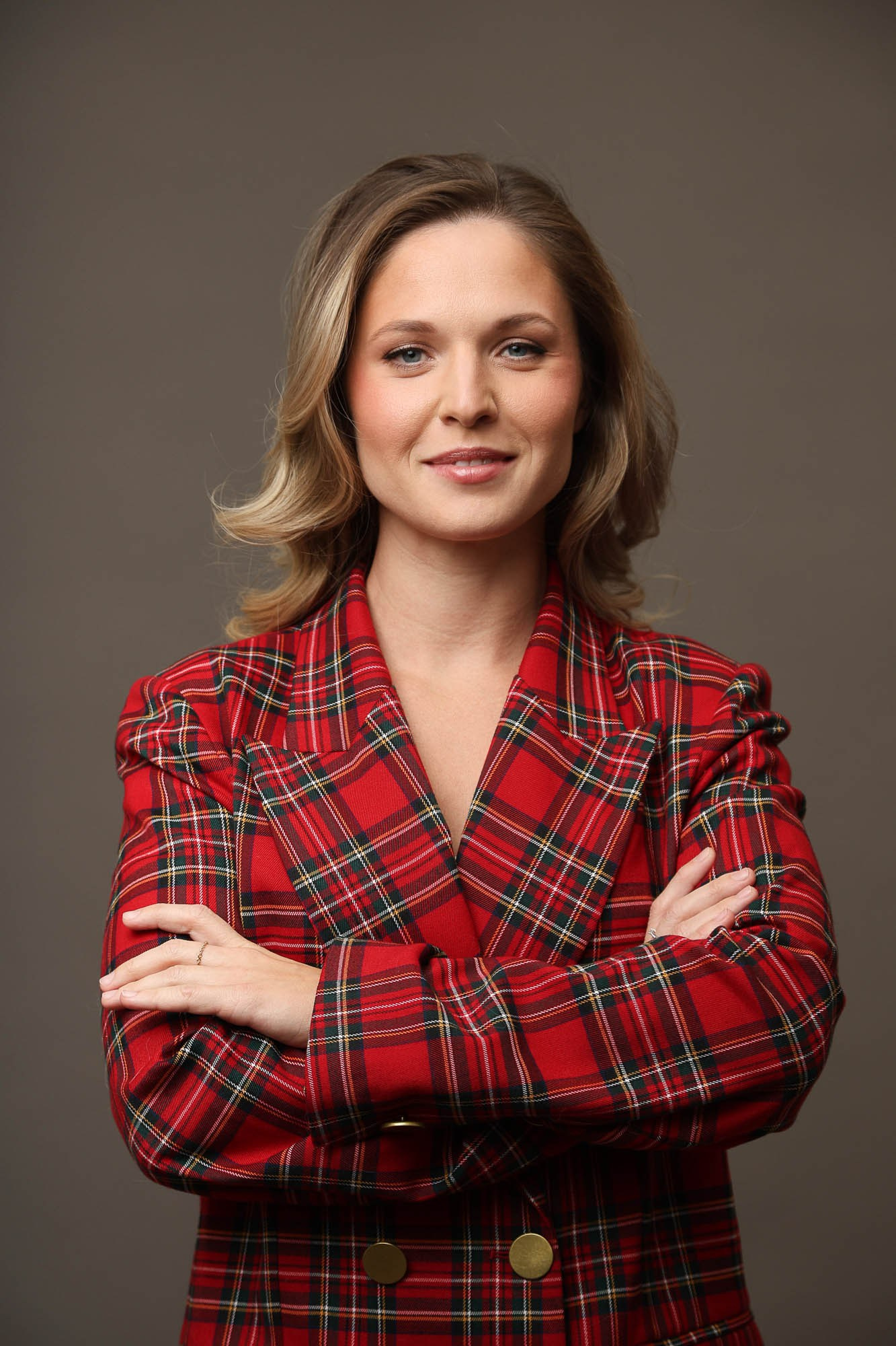 Фото бизнес леди на серо-коричневом фоне в клетчатом костюме