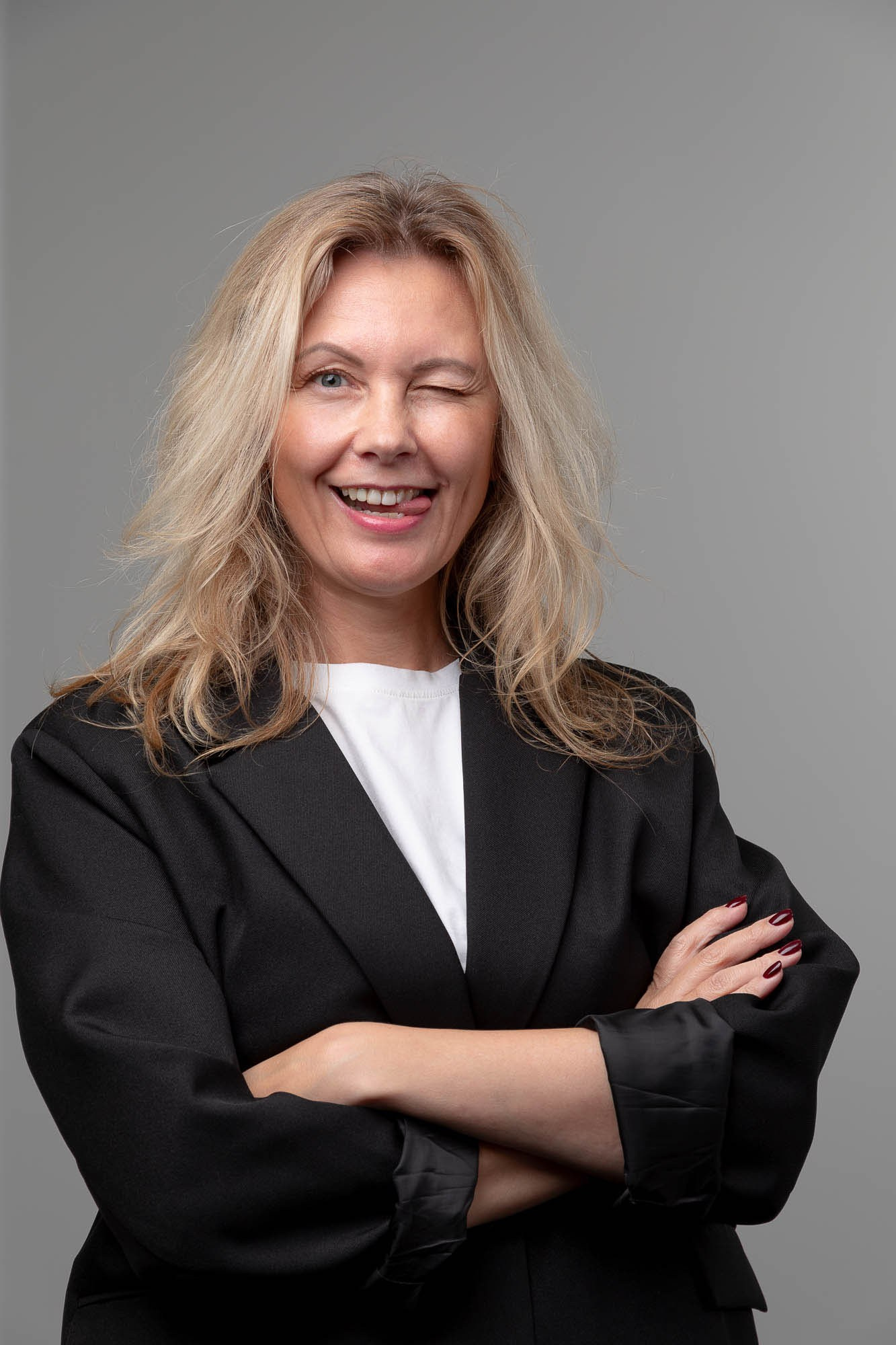 Веселая девушка в бизнес стиле на сером фоне