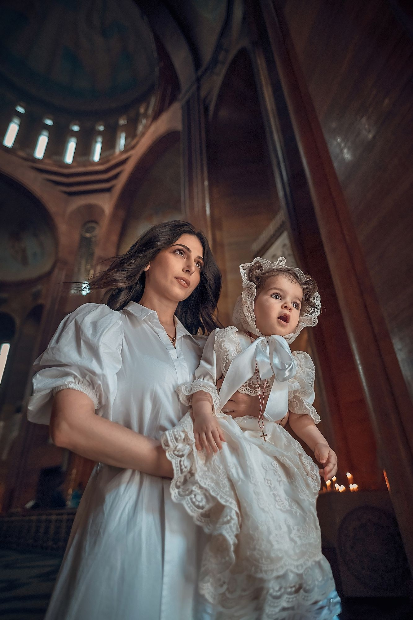 Профессиональная видеосъемка венчания и крещения в Москве: таинство в православном храме Красивая видеосъемка крещения ребенка в церкви Москвы: крупный план младенца и священника Видеосъемка обряда венчания в храме: молодожены держат венцы над головами Услуги видеографа на крестины и венчание в Москве: эмоциональный кадр церемонии