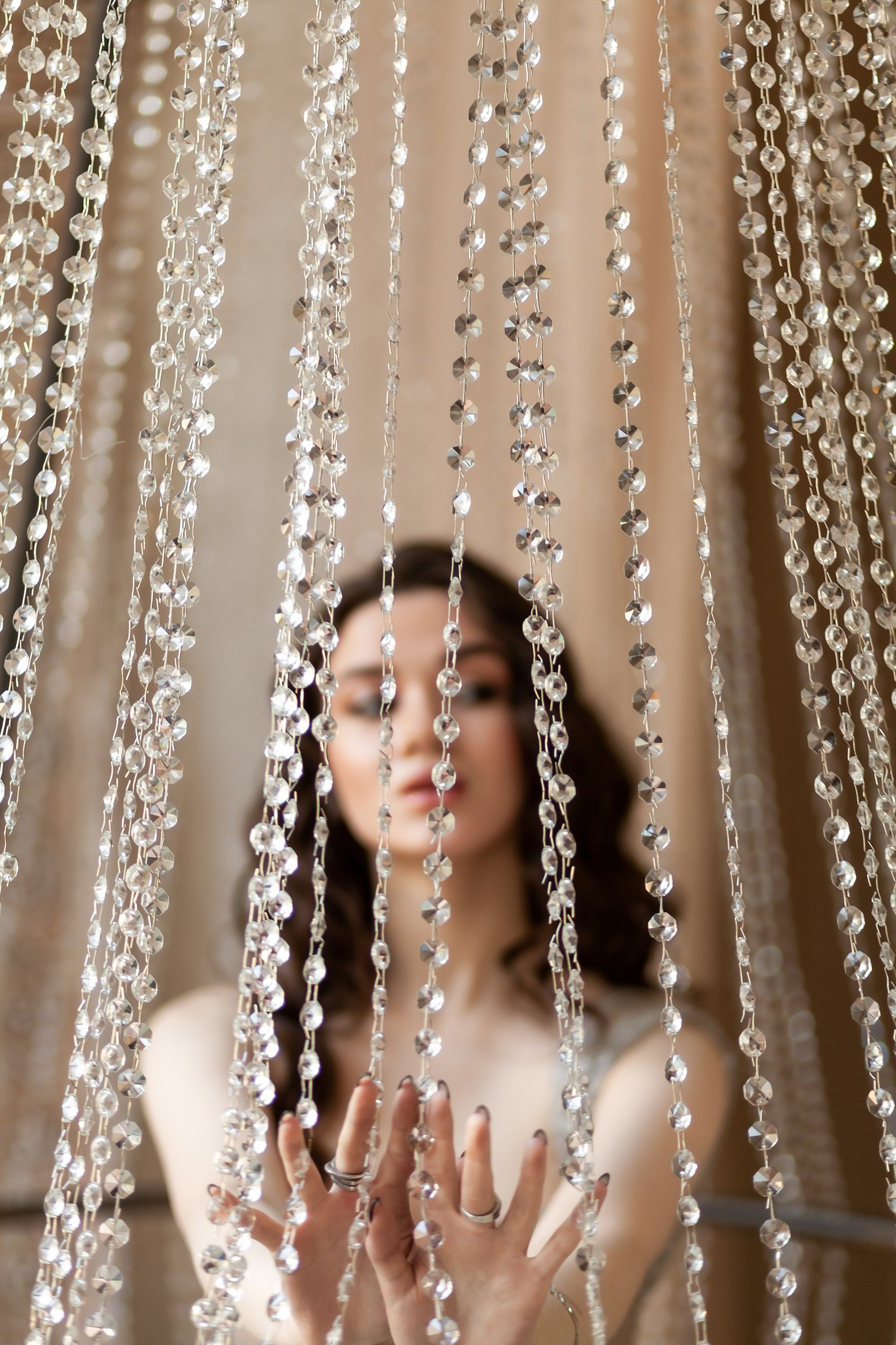 Креативный портрет девушки сквозь хрустальную люстру