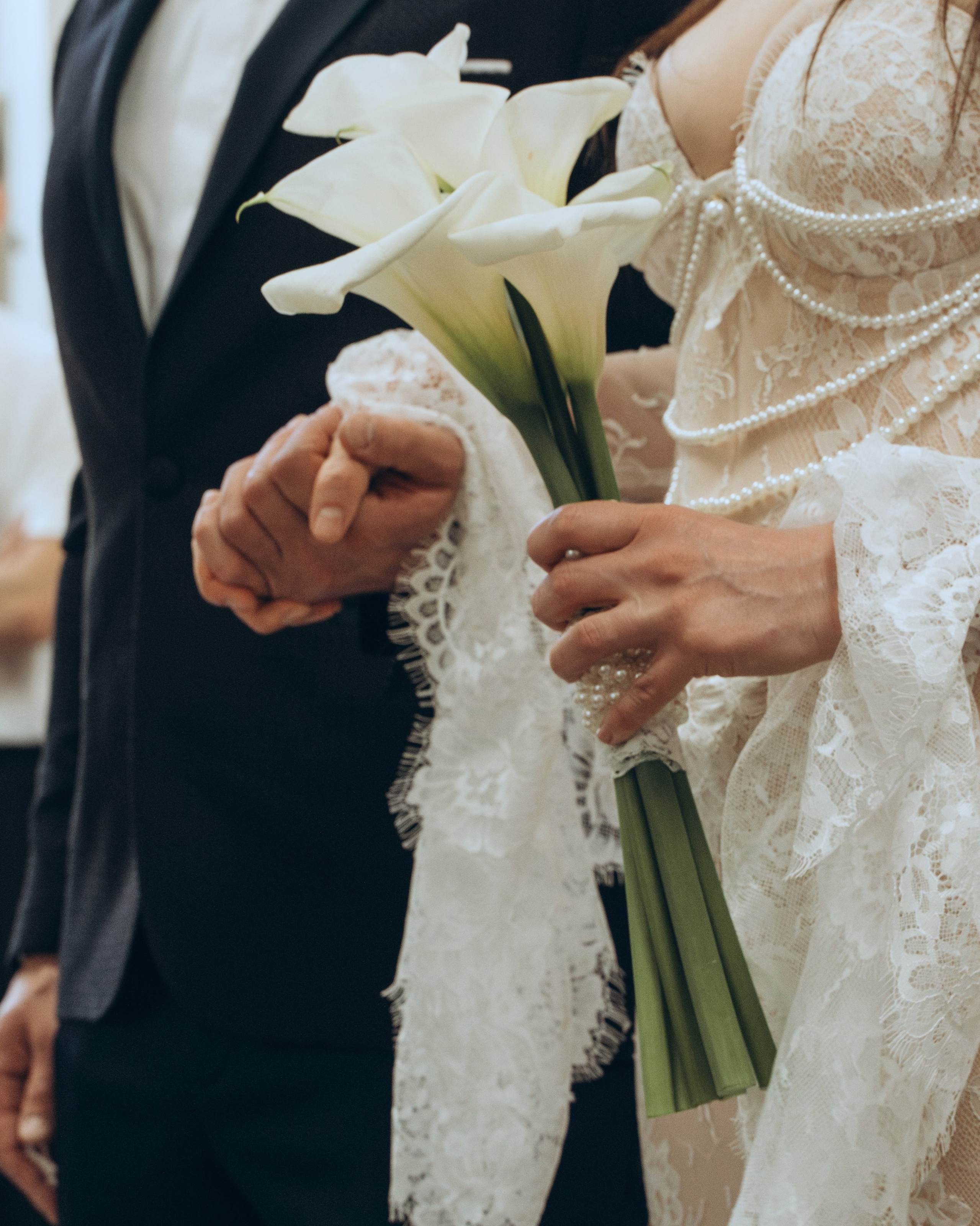 Mariés main dans la main avec un bouquet de callas, formule cérémonie, tarifs photographe mariage Nîmes
