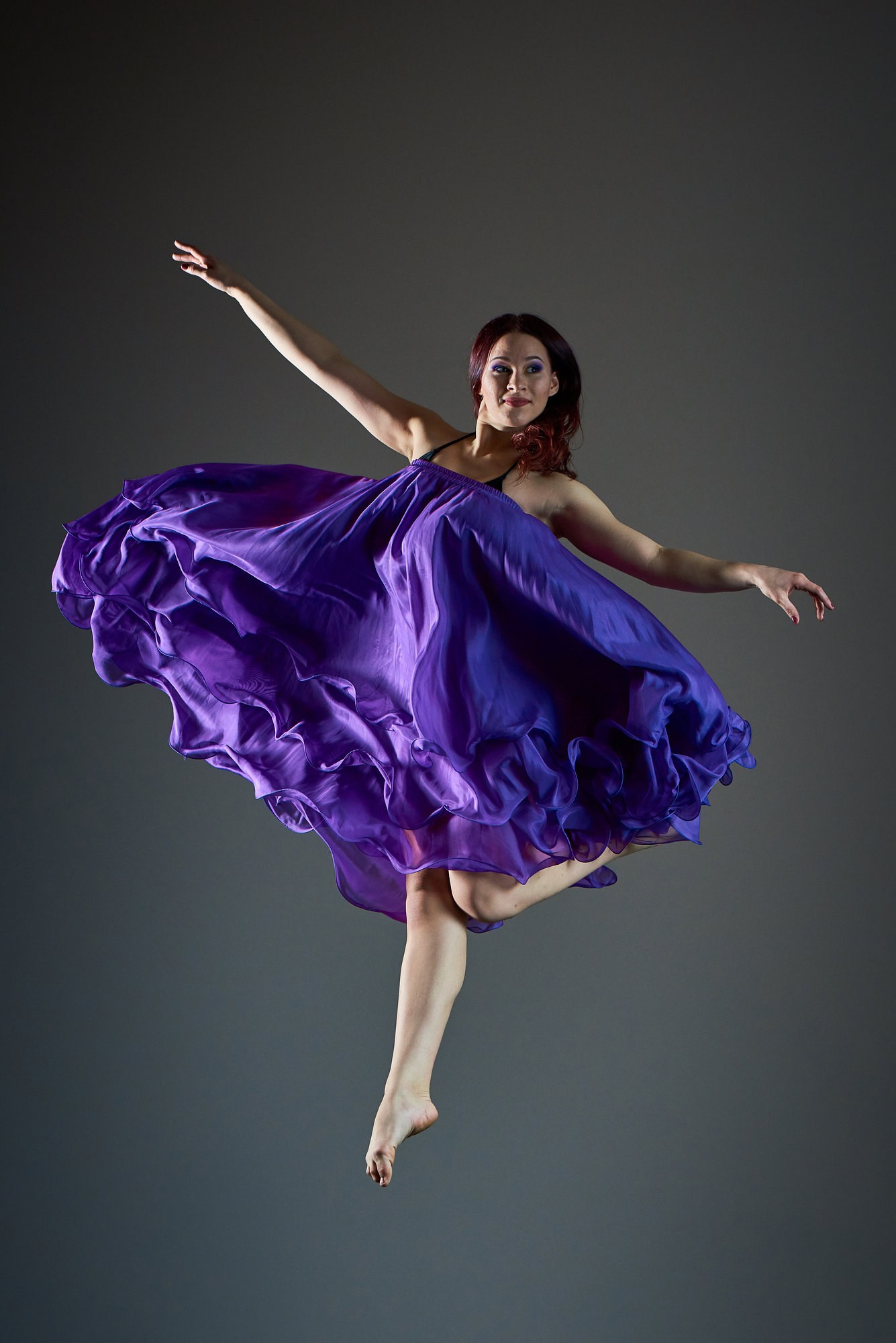 Две танцовщицы синхронно раскрывают фиолетовые юбки в воздушном развороте, создавая эффект взрыва цвета и движения. Постановочная фотосъёмка. Фотограф Александр Шадрин, Москва и Истринский район