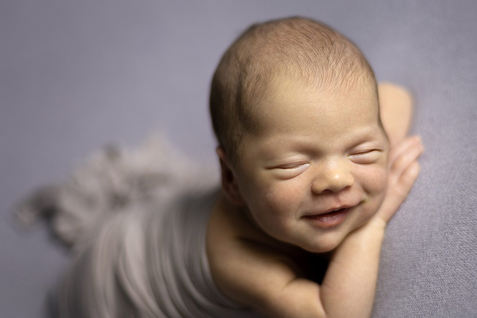 Новорождённый малыш в позе на животике