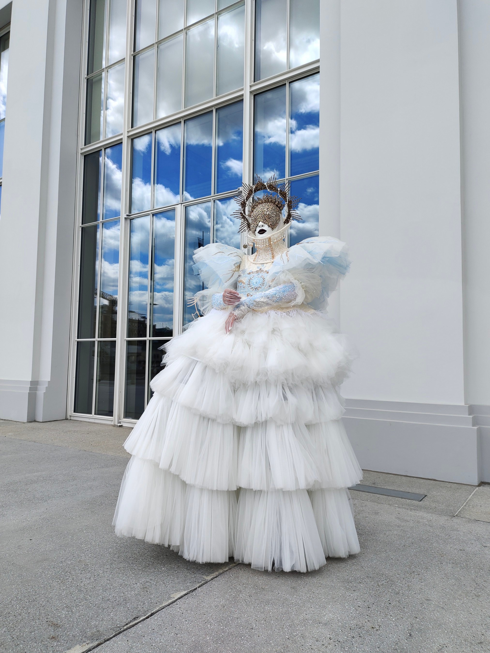 Белый ангел без крыльев на свадьбе у ресторана с большими окнами