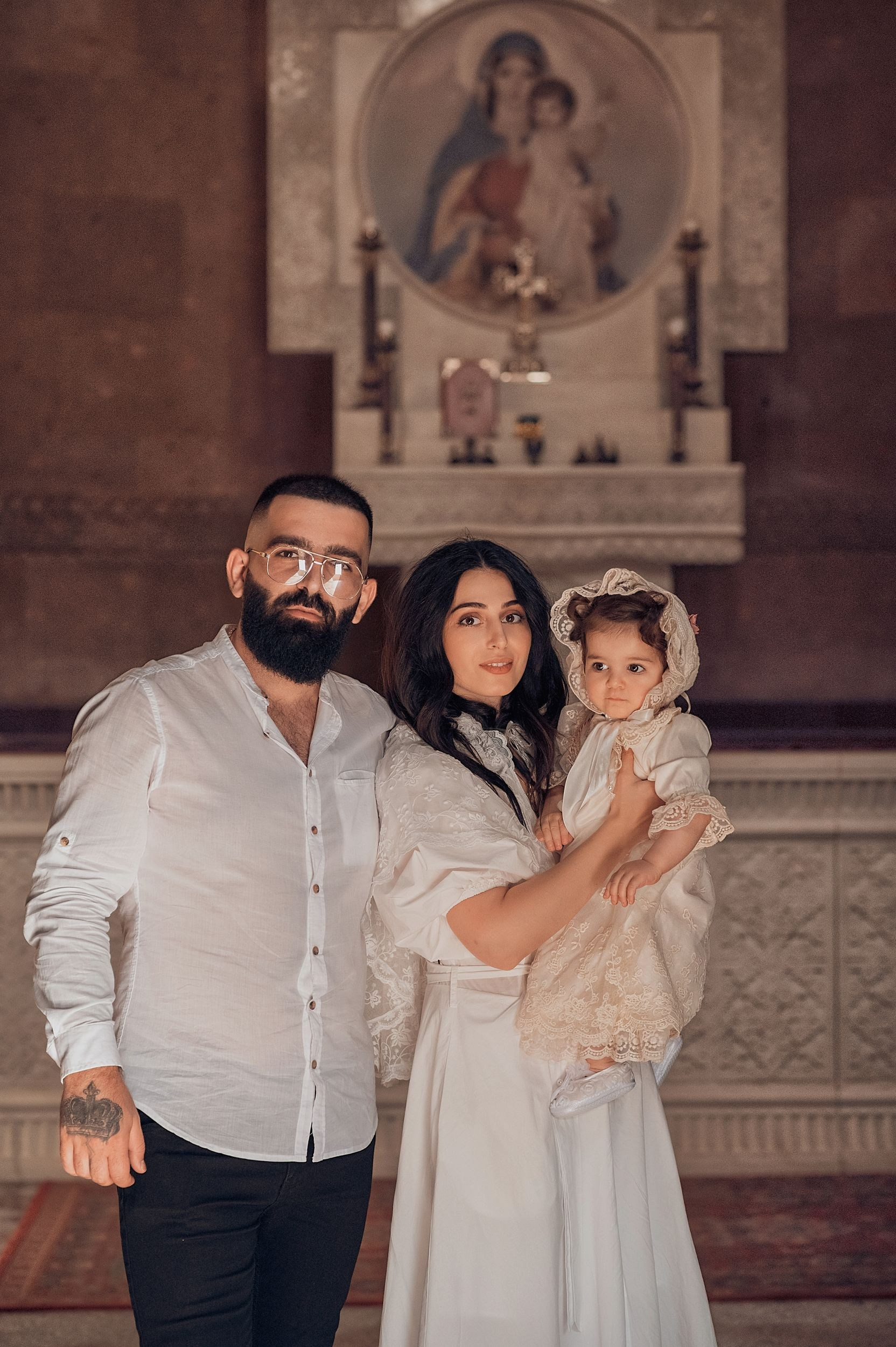 Профессиональная видеосъемка венчания и крещения в Москве: таинство в православном храме Красивая видеосъемка крещения ребенка в церкви Москвы: крупный план младенца и священника Видеосъемка обряда венчания в храме: молодожены держат венцы над головами Услуги видеографа на крестины и венчание в Москве: эмоциональный кадр церемонии