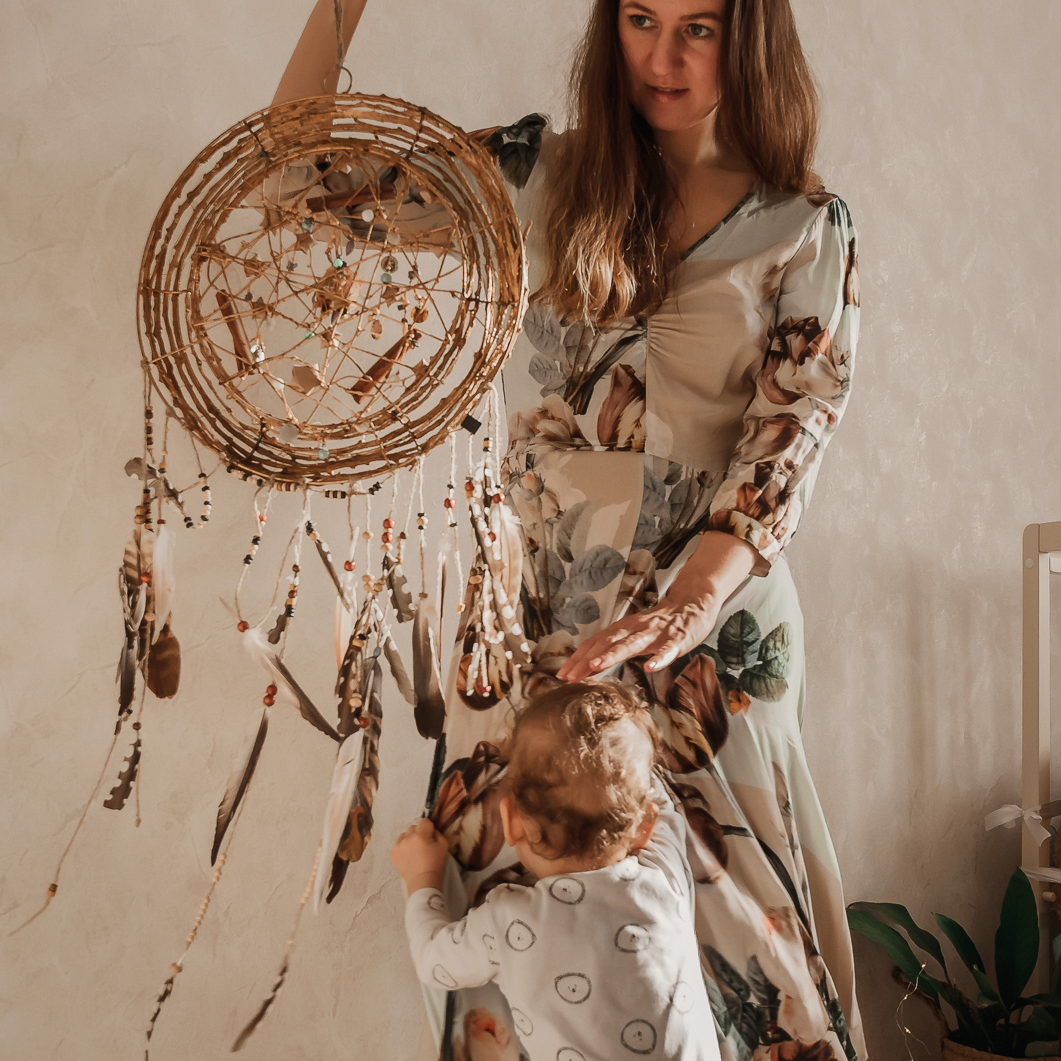 Мама и малыш играют вместе с ловцом снов