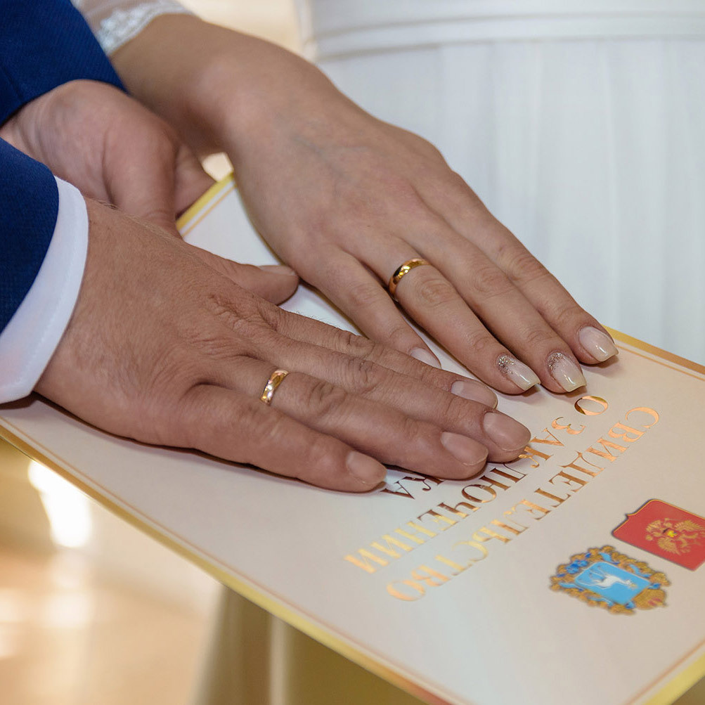 свадебная фотосессия молодожены держат в руках свидетельство о браке