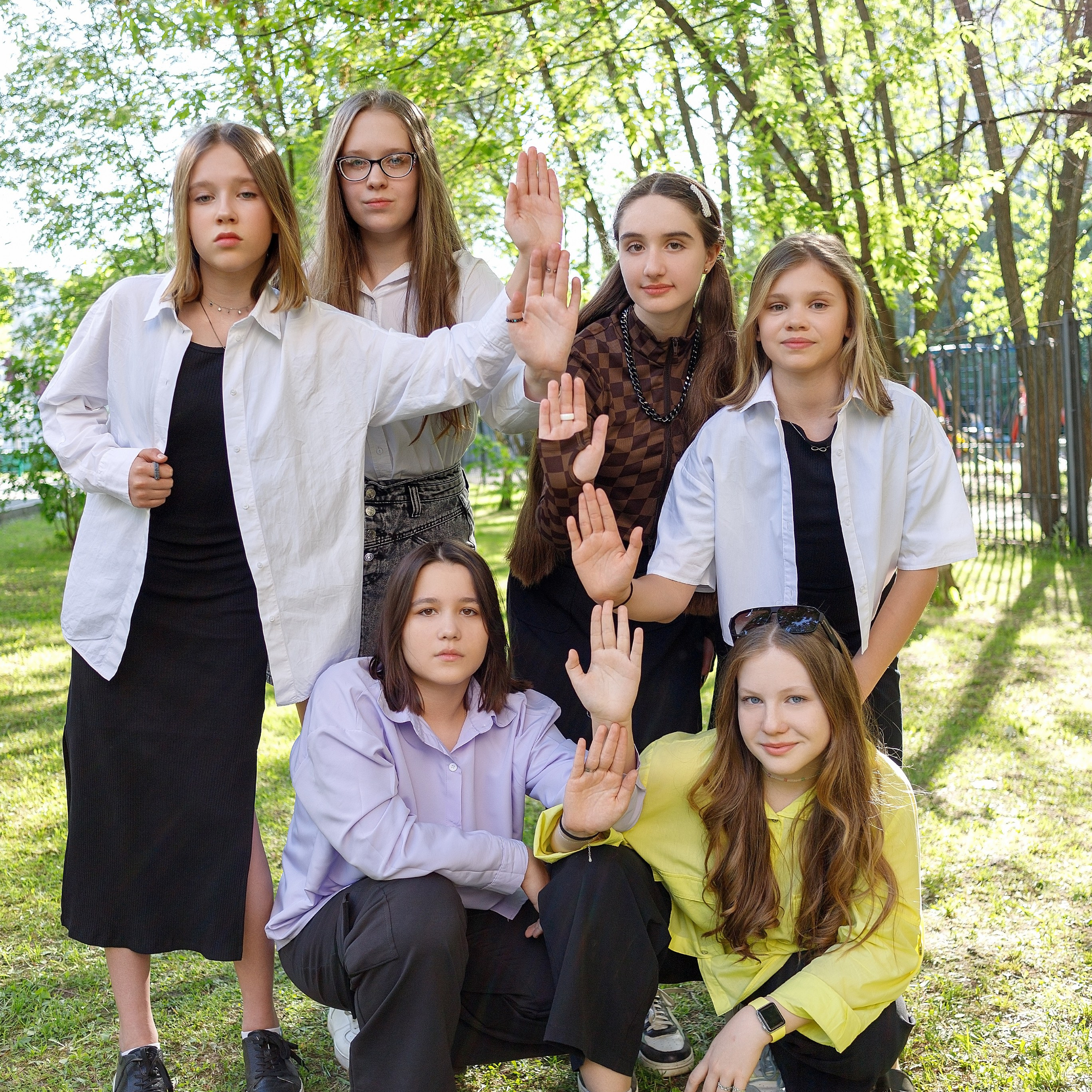 Школьники в форме "галочки" вместе с учителем вшестером стоят у доски.