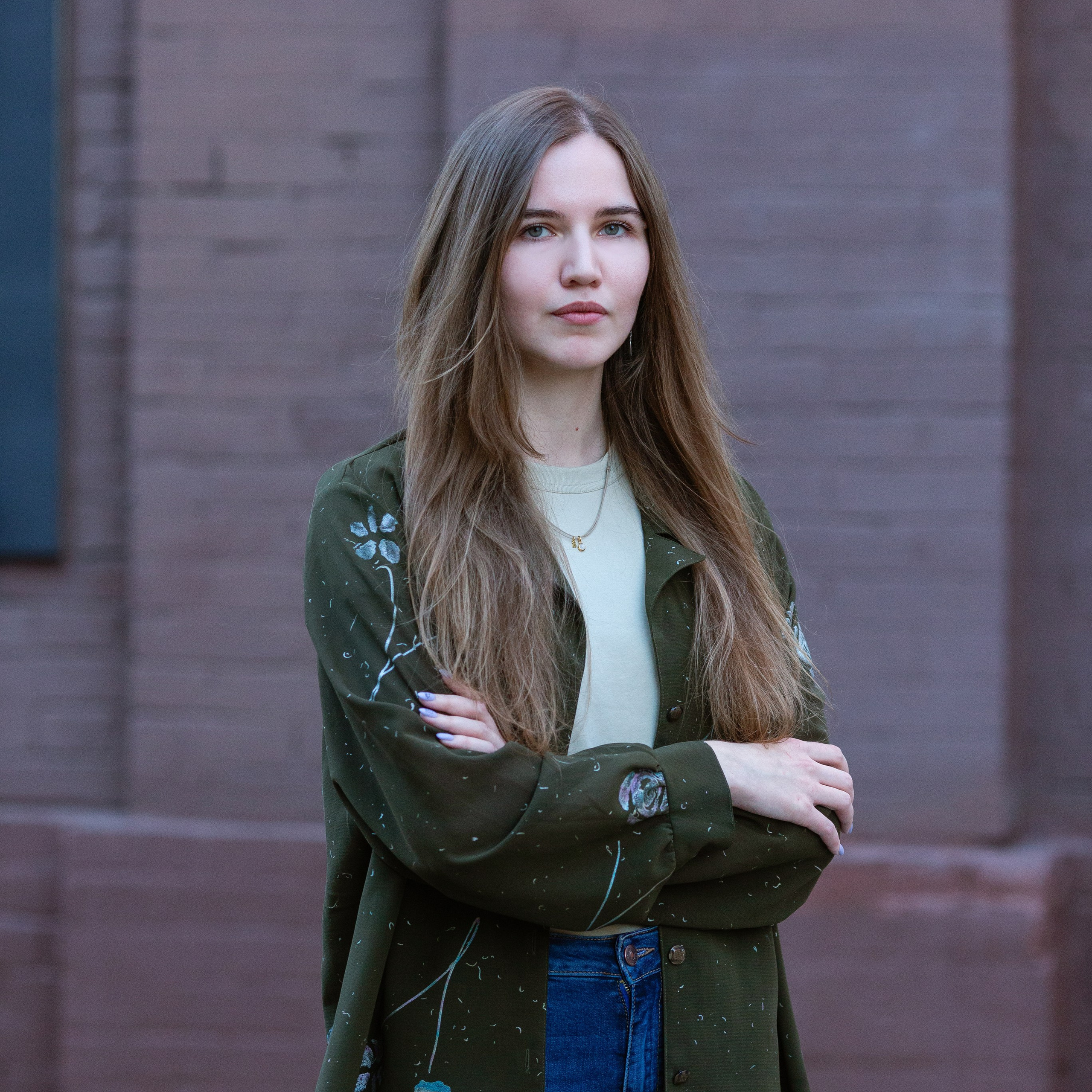 Классный руководитель в синем бархатном платье сидит на кресле.