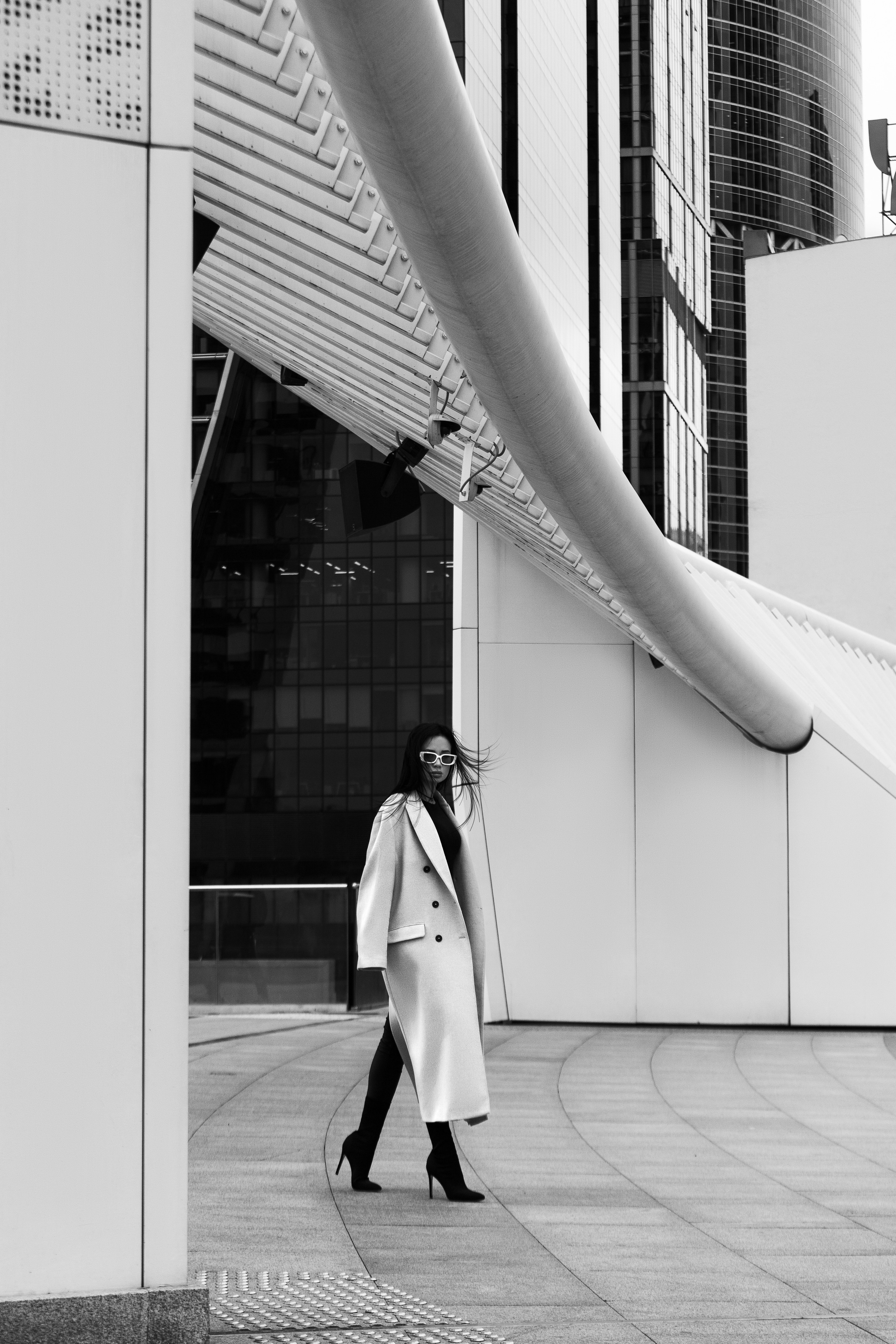 Девушка в белом пальто на фоне небоскребов