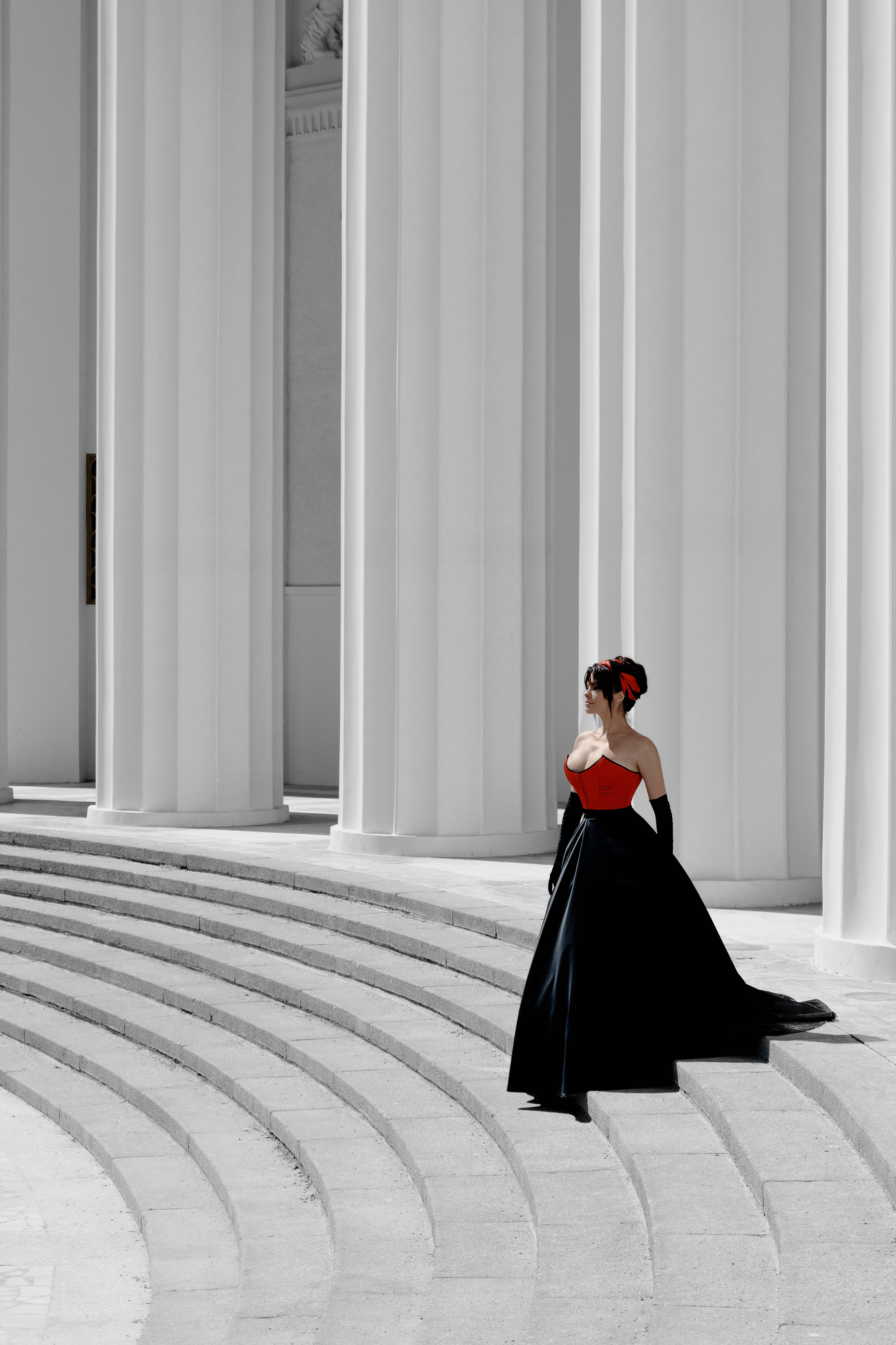 Девушка в красном платье на фоне колонн