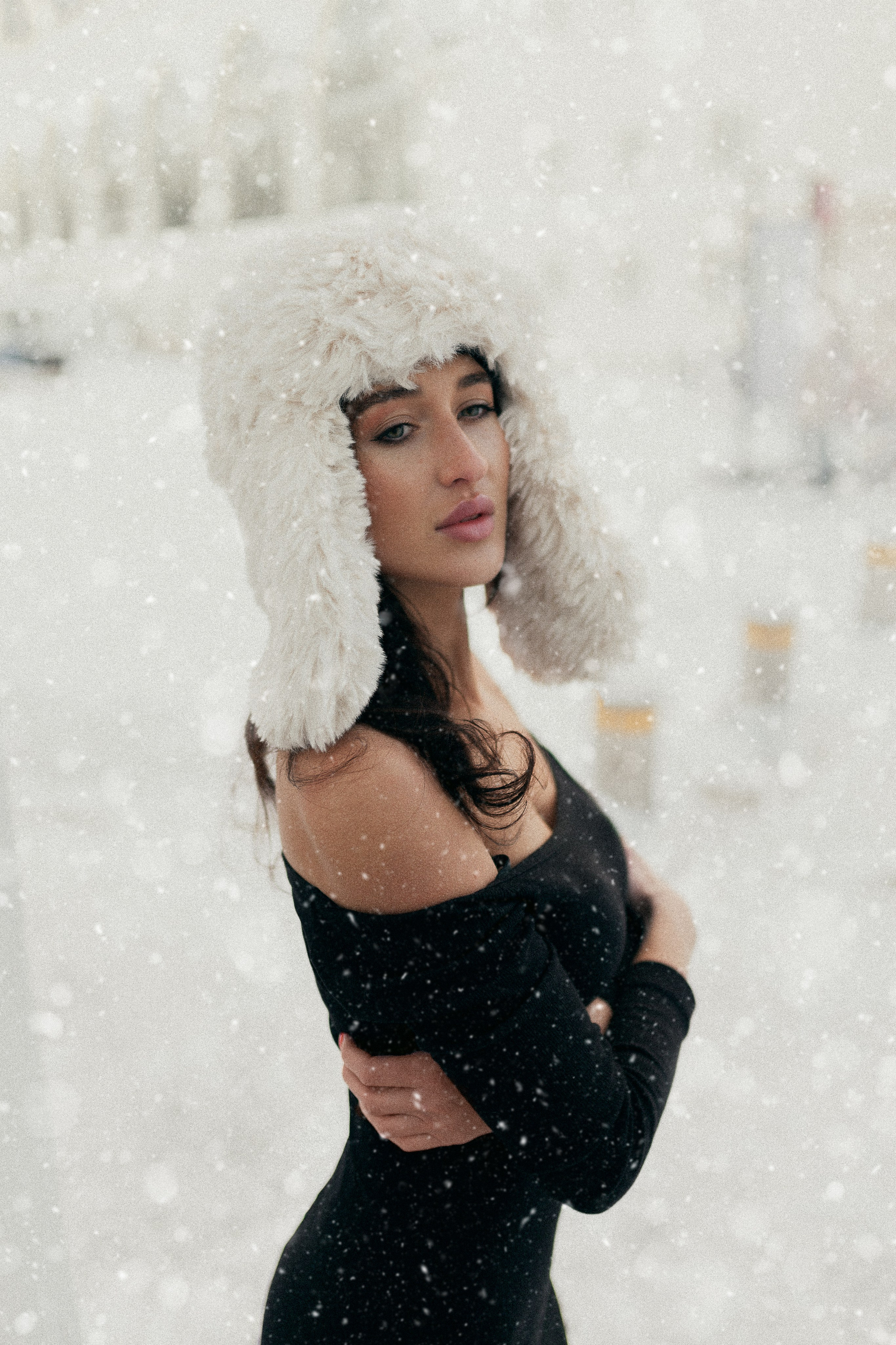 Девушка в черном платье и в белой меховой шапке