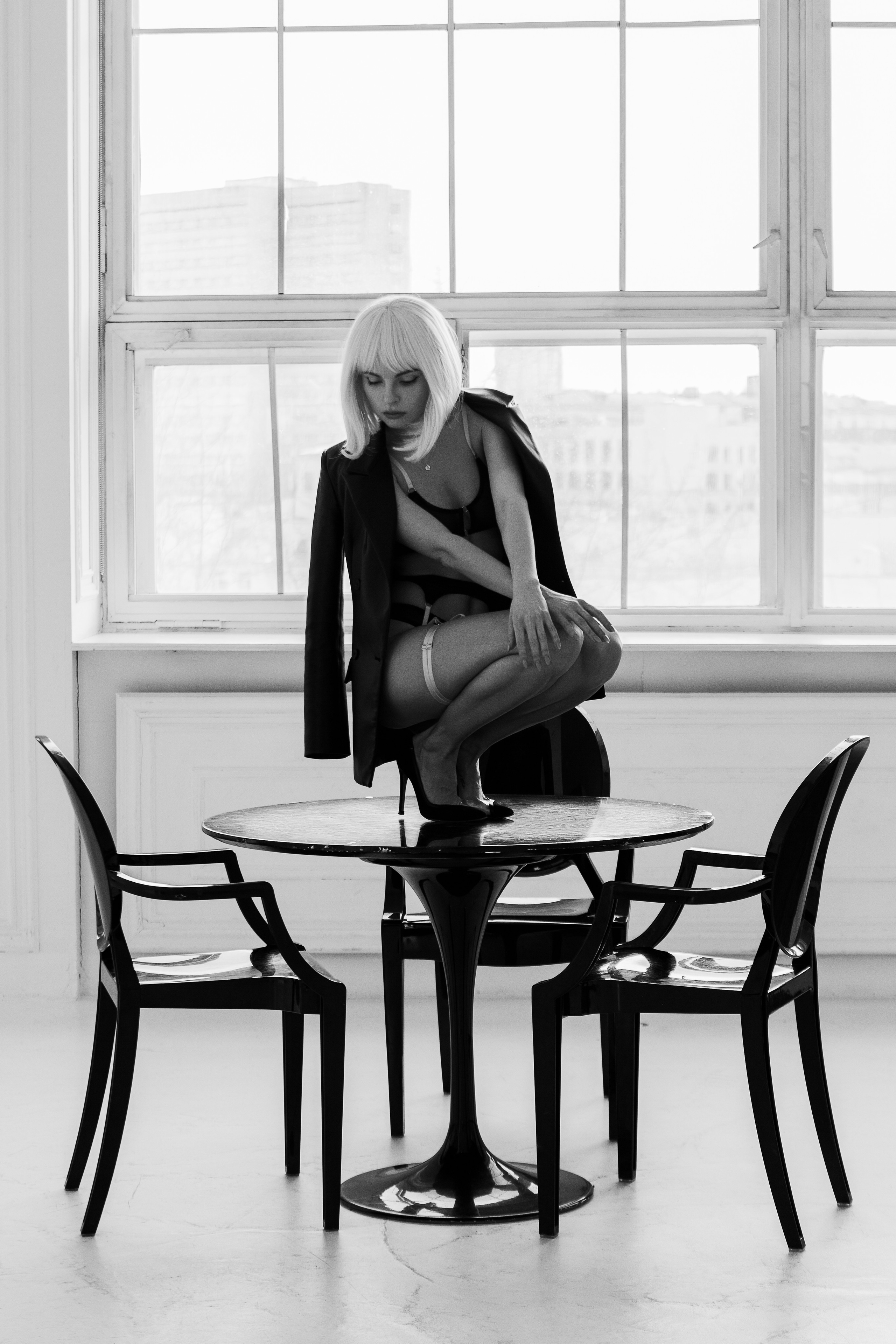 Девушка в белье сидит на столе