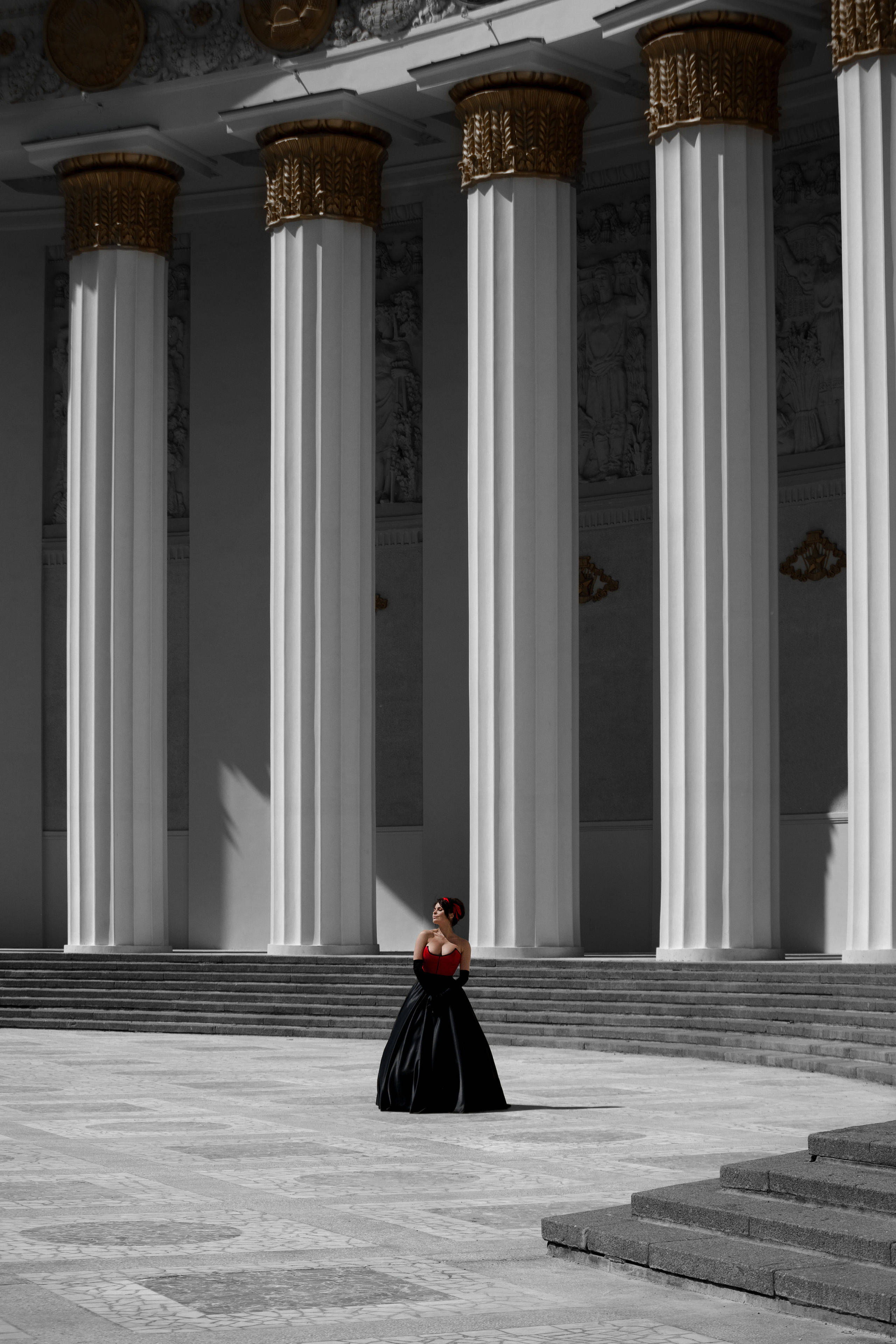 Девушка в красном платье на фоне колонн