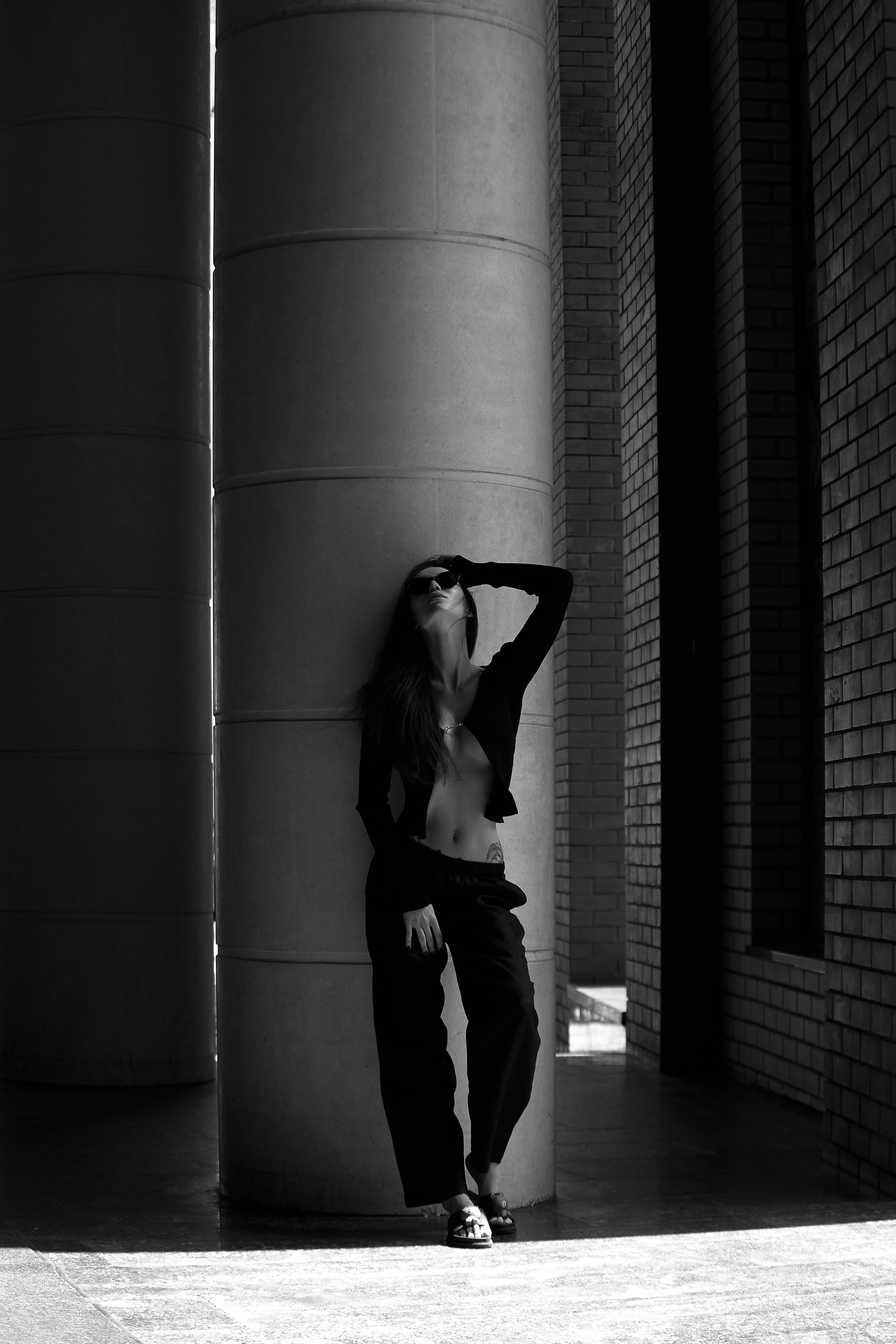 Девушка в черном костюме на фоне колонн