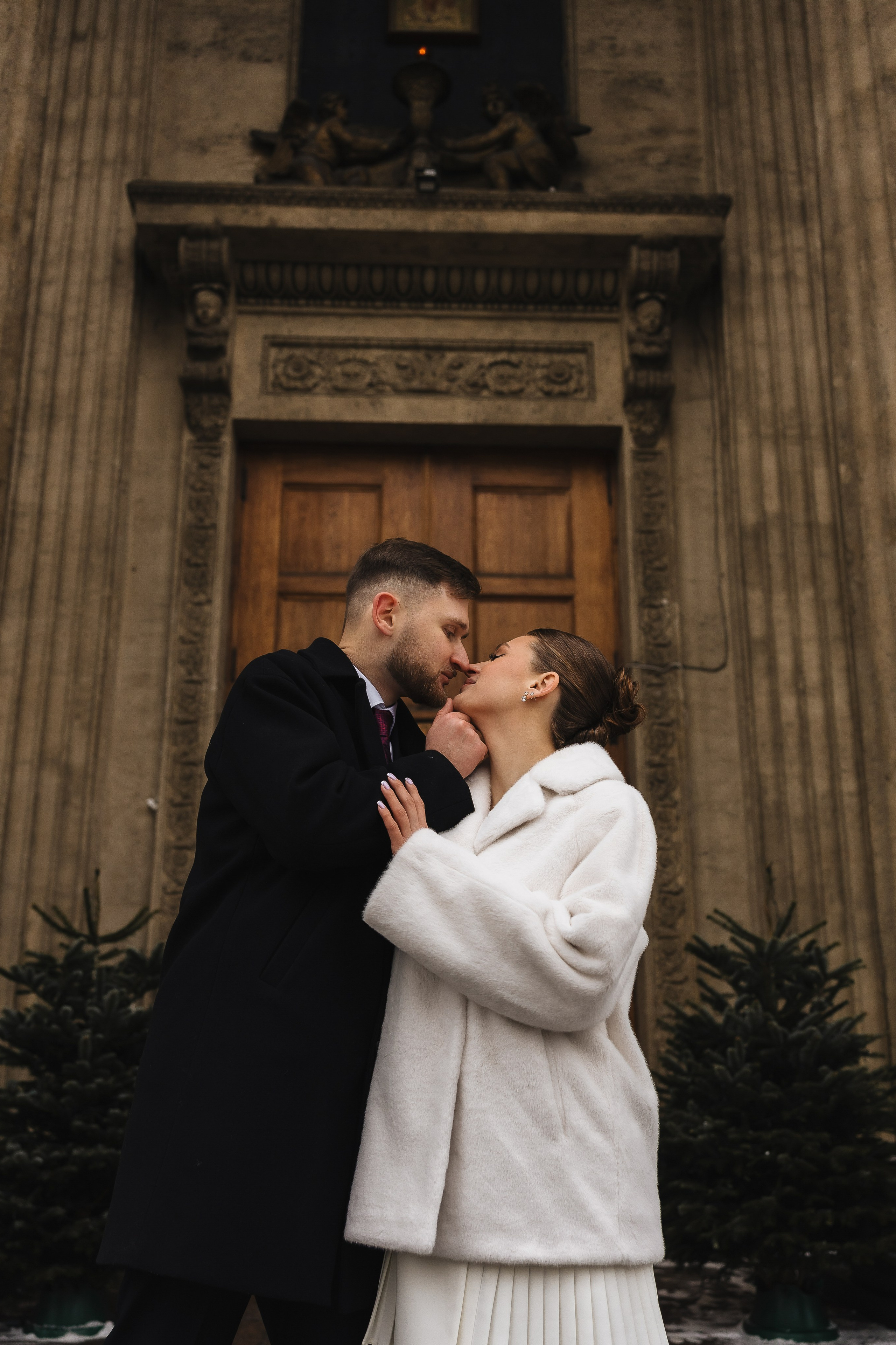 Свадебное фото у двери. Пара в белом на фоне старинной архитектуры