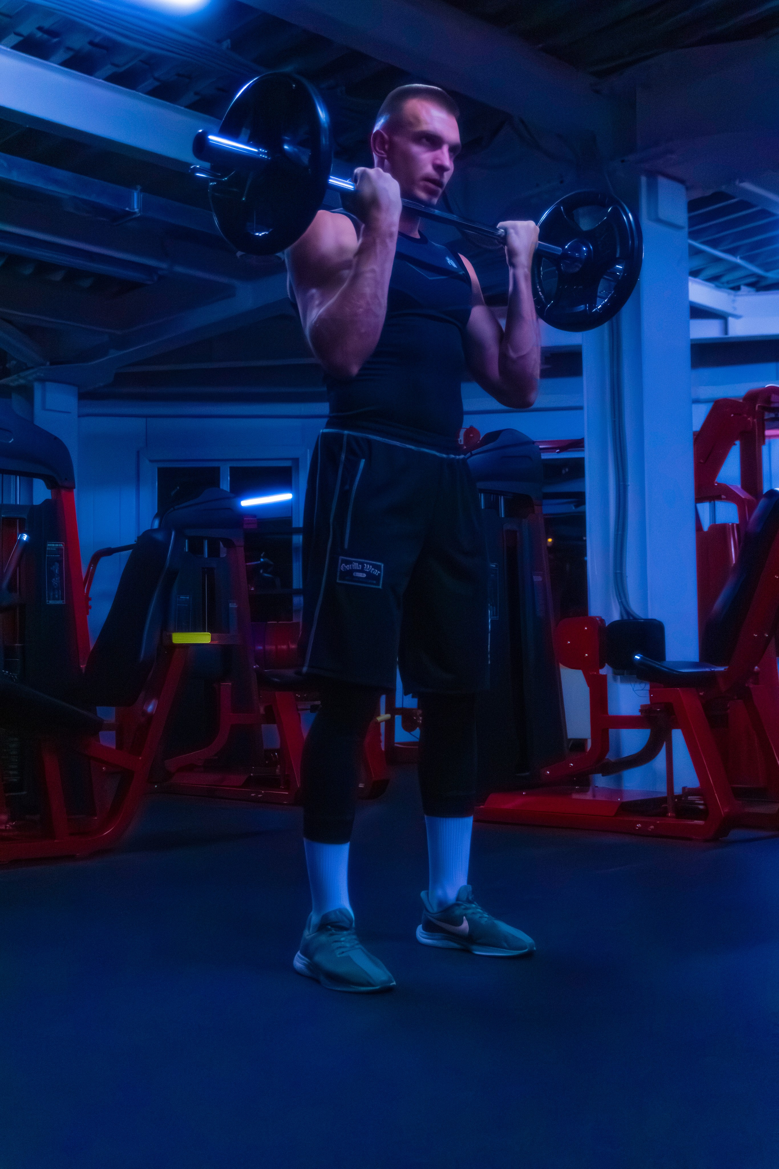 Элегантная съемка тренера в современном зале, передающая красоту тела.