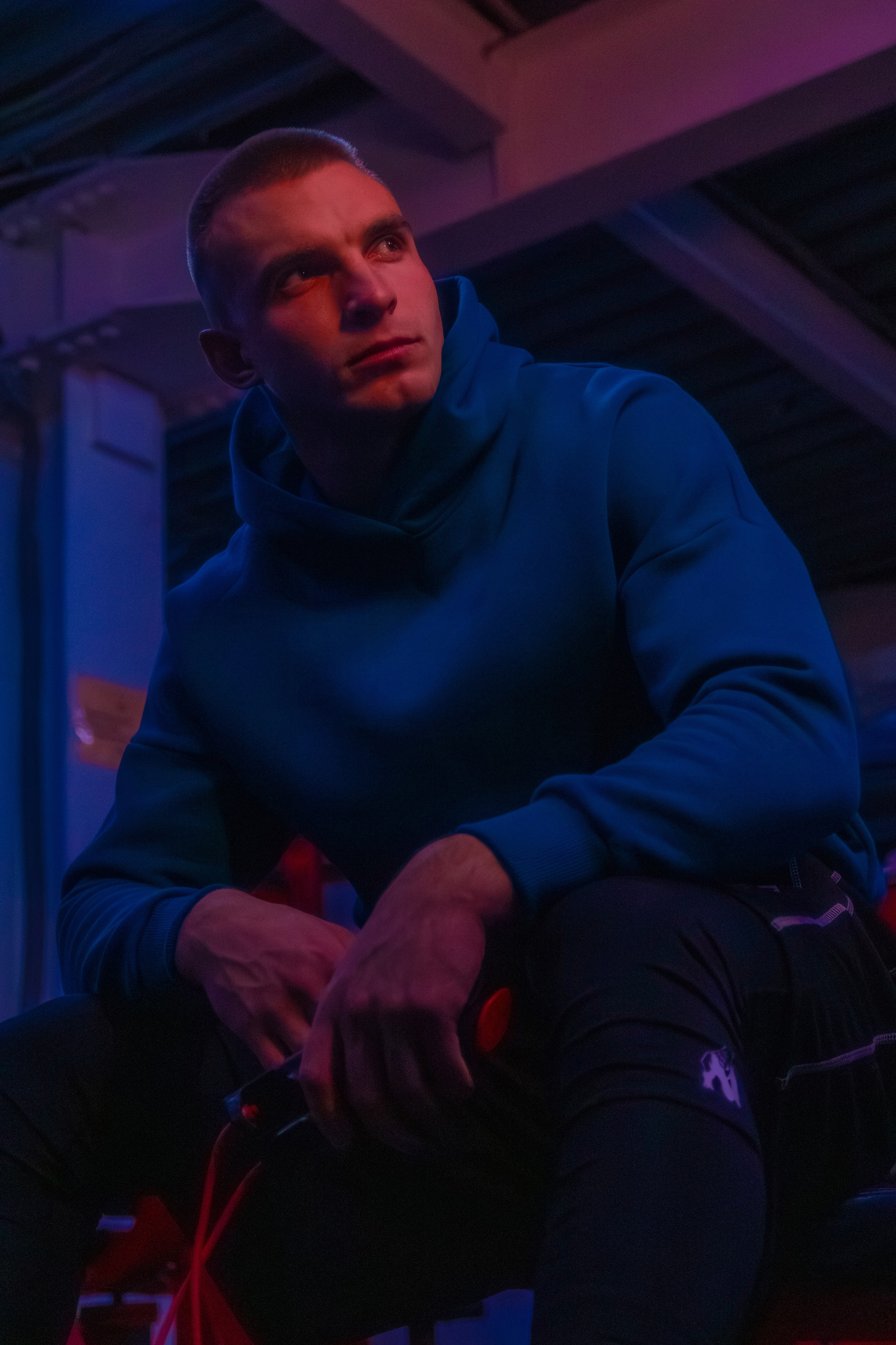 Модный кадр фитнес-эксперта, где свет подчеркивает атлетическую фигуру.