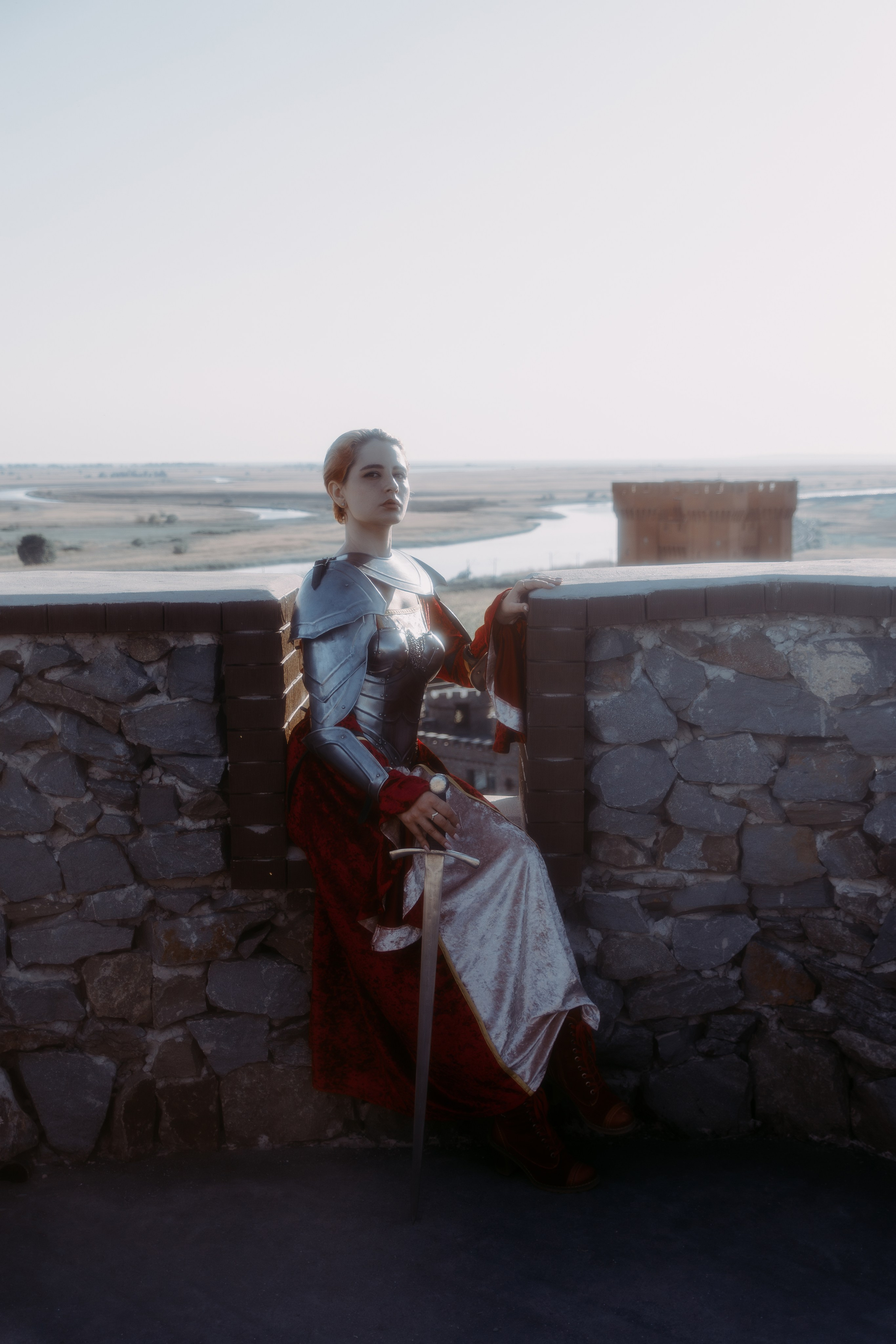 Девушка рыцарь сидит на краю крыши рыцарского замка