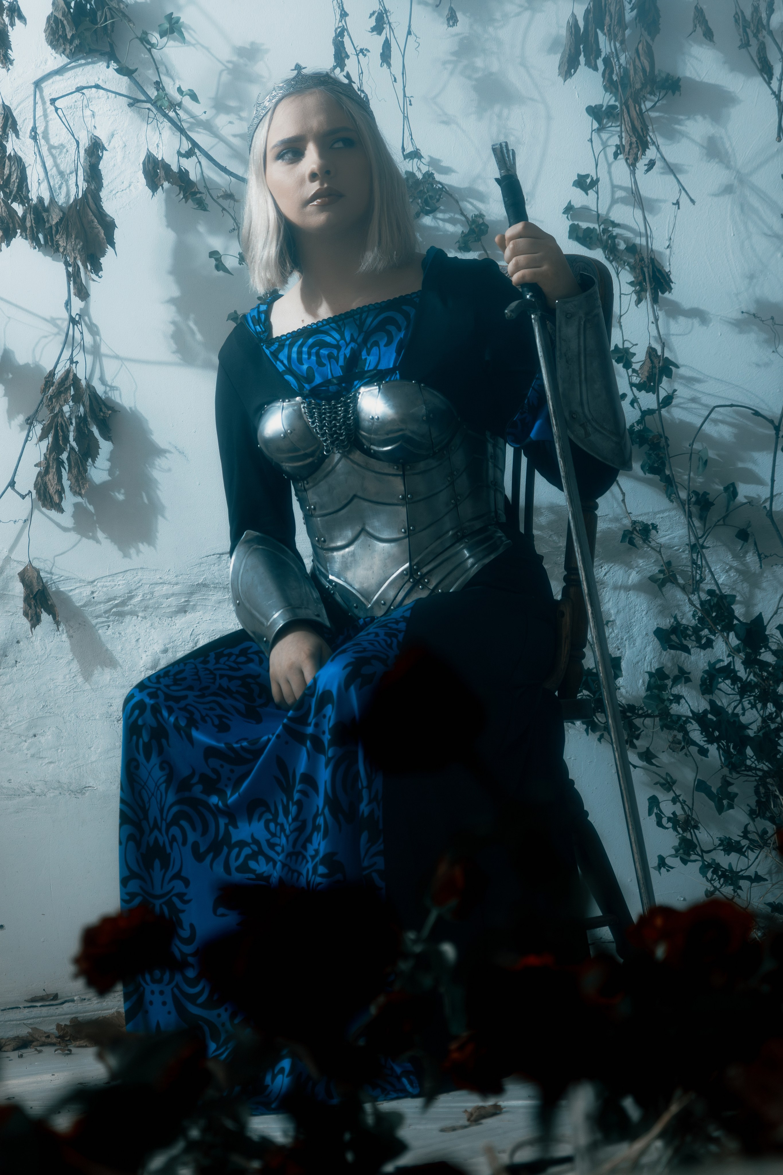 Драматичный образ девушки-воина в блестящих рыцарских доспехах. Напряженность позы создает динамику.