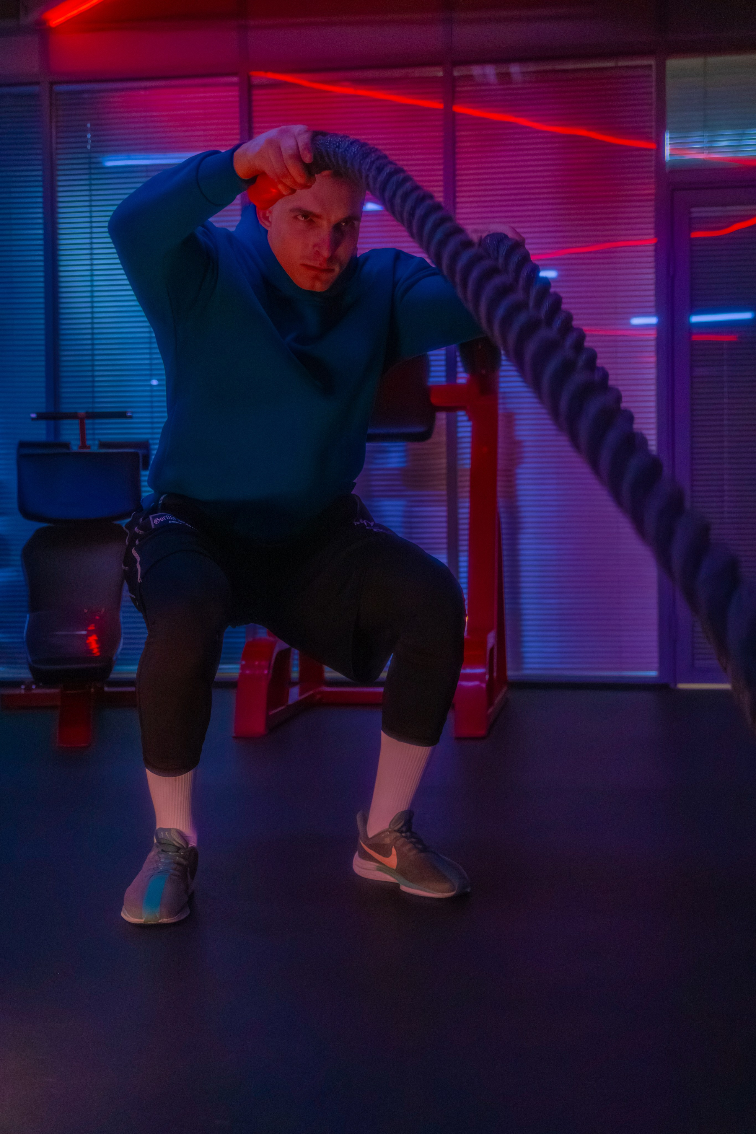 Эффектная фотография атлета, где неоновые огни акцентируют внимание на мышцах.