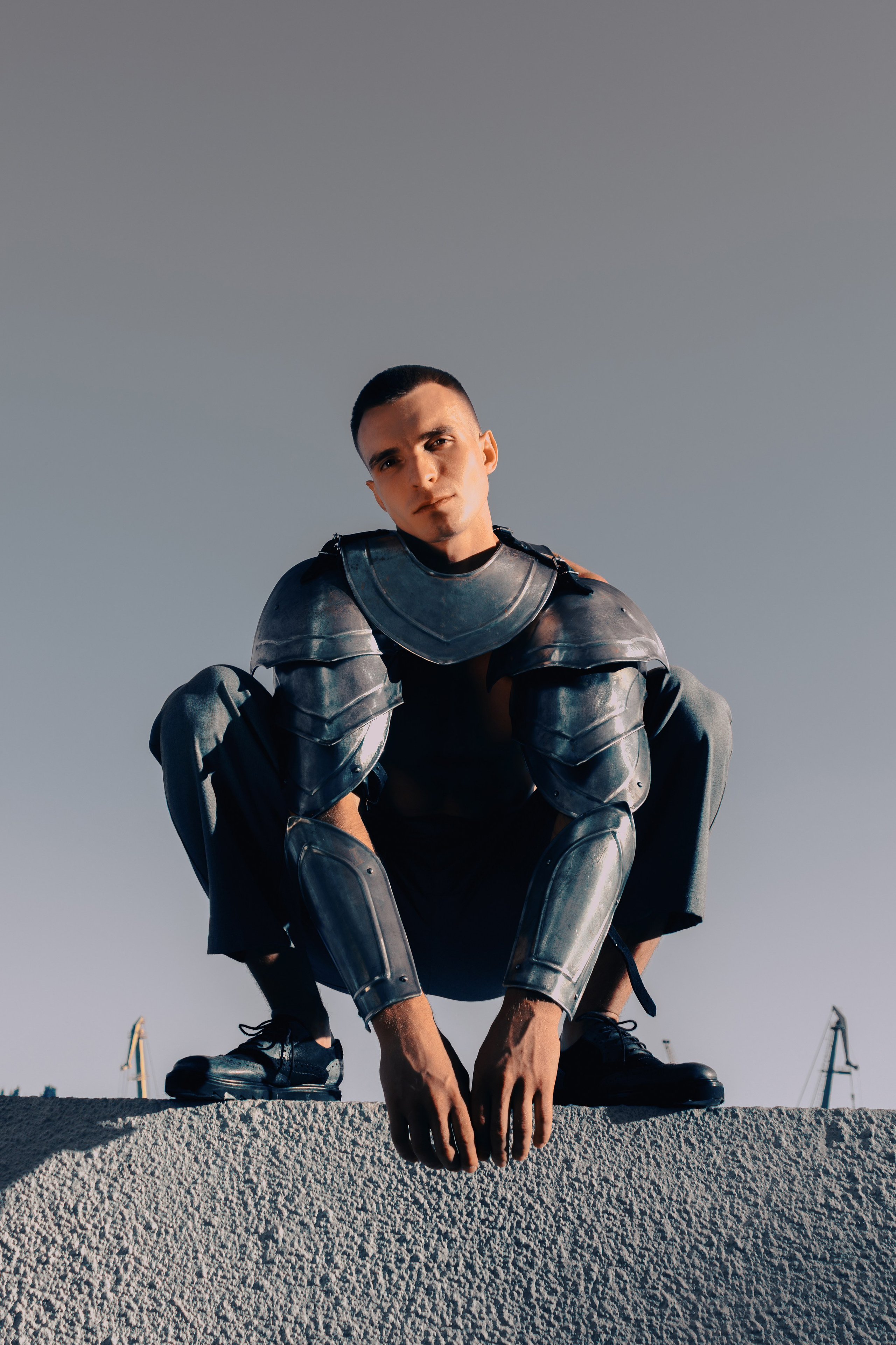 Мужчина в рыцарских доспехах сидит на корточках на Набережной Ростов-на-Дону