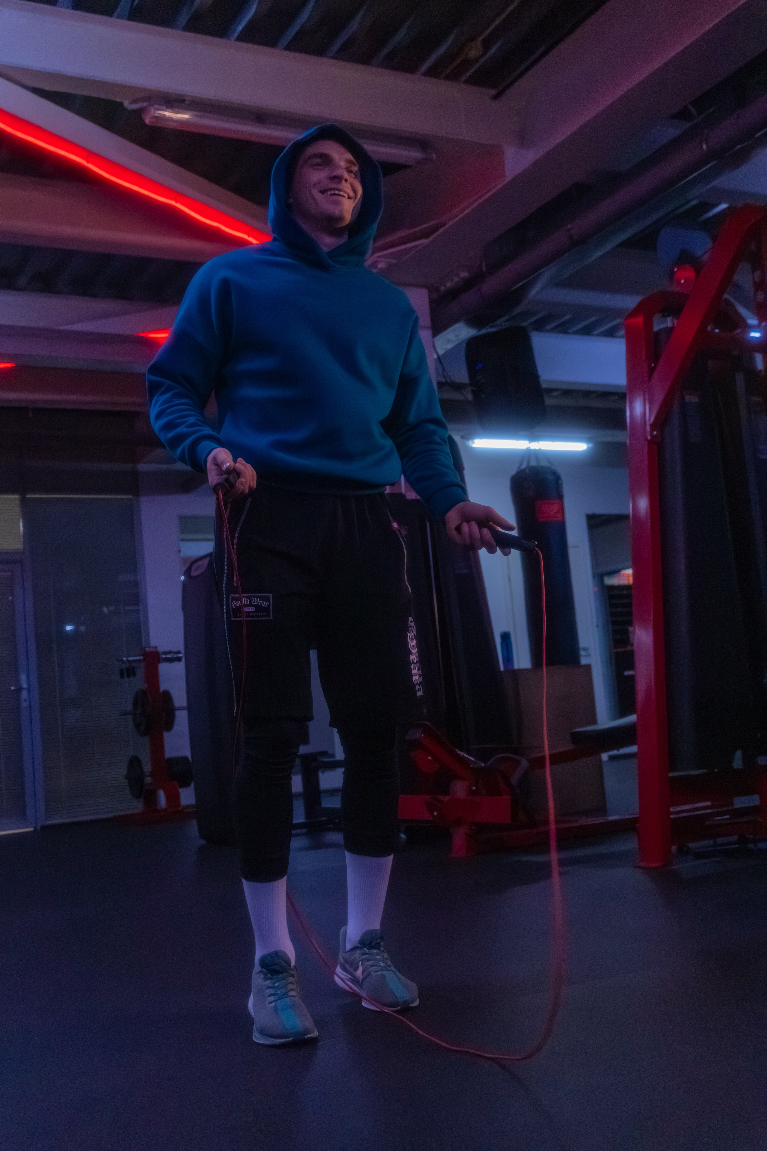 Стильный снимок инструктора в атмосфере ночного фитнеса, акцентирующий внимание на красоте тела.