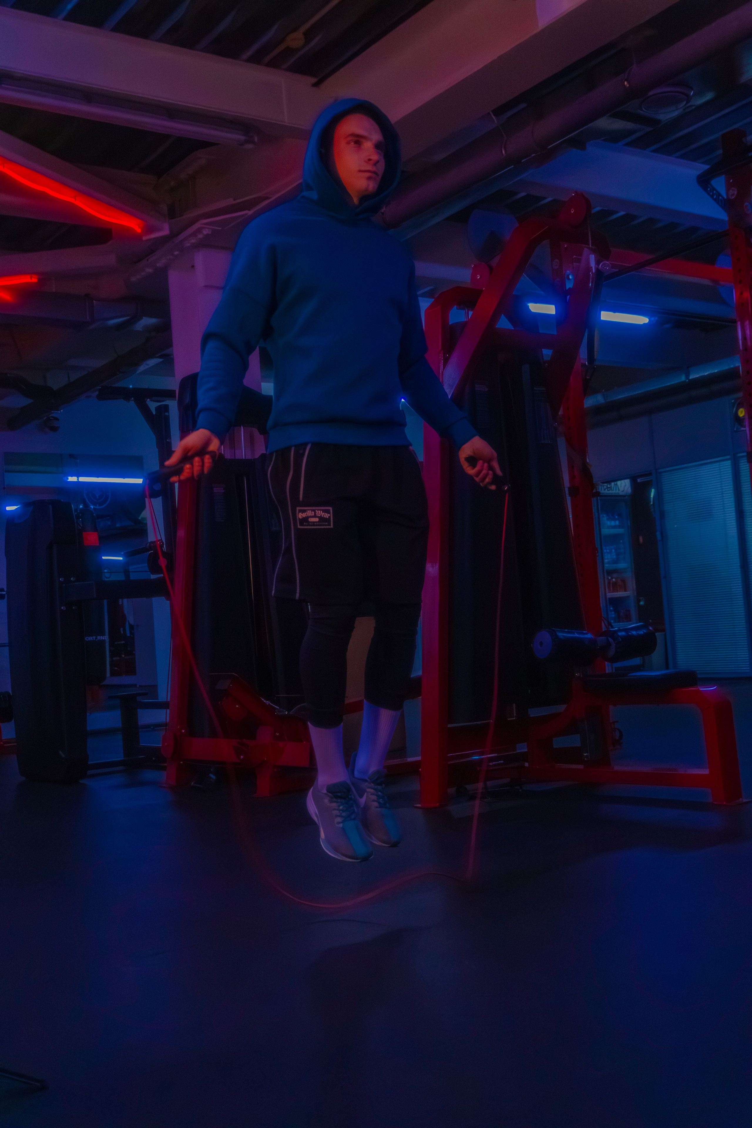 Журнальный портрет тренера с идеальным рельефом в атмосфере современного фитнеса.