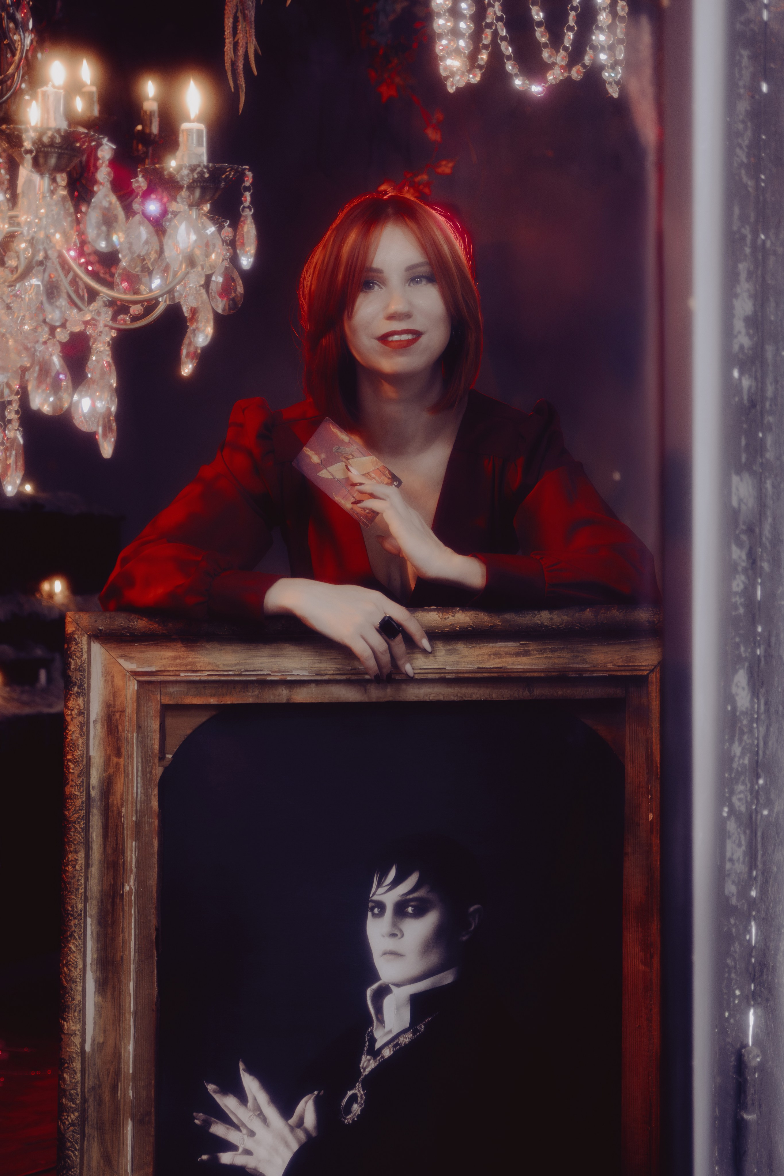 Таролог в задумчивой позе у студийного окна. Естественный свет льётся сбоку, выделяя профиль.