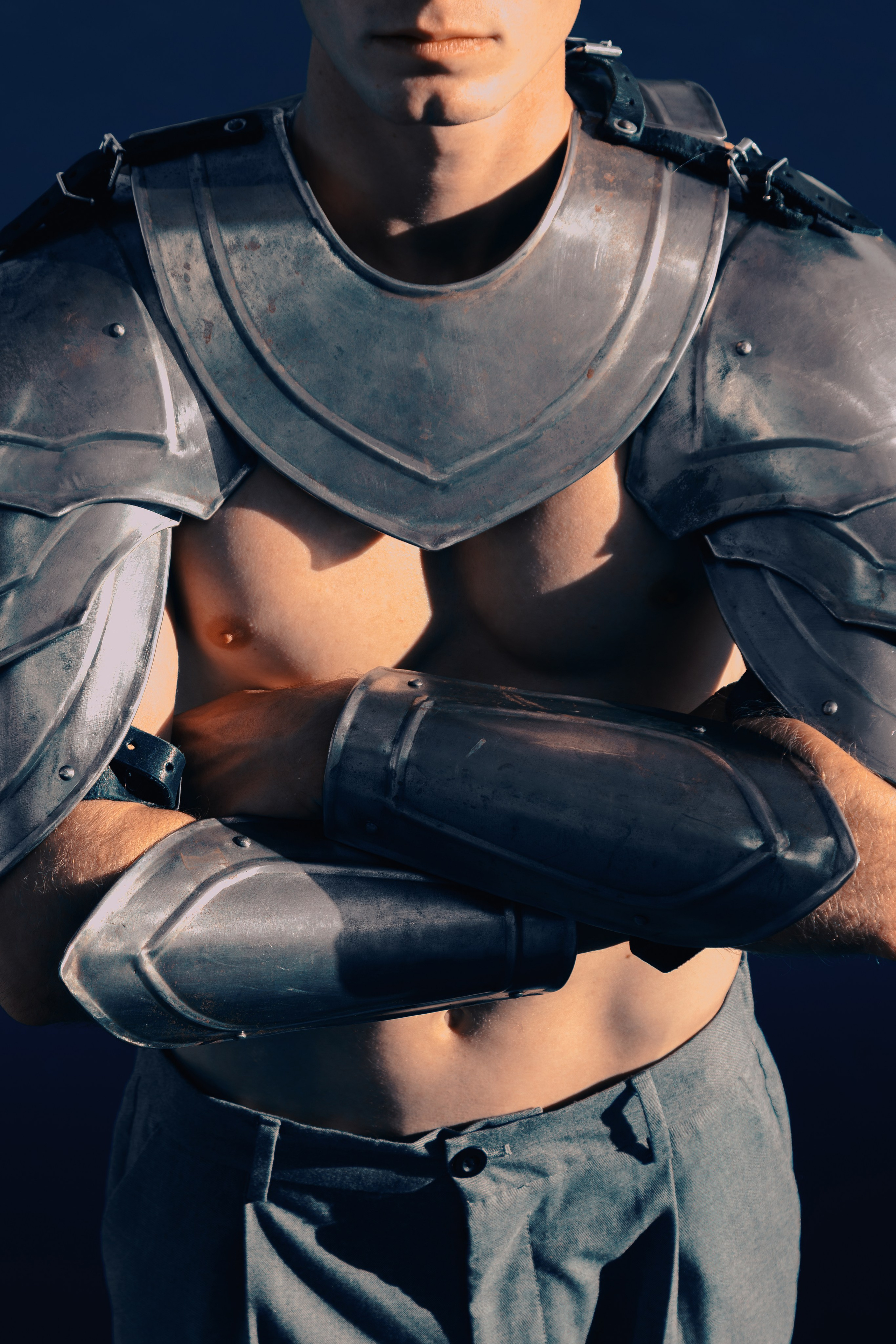 Рыцарские доспехи крупным планом. У мужчины сложены руки на груди