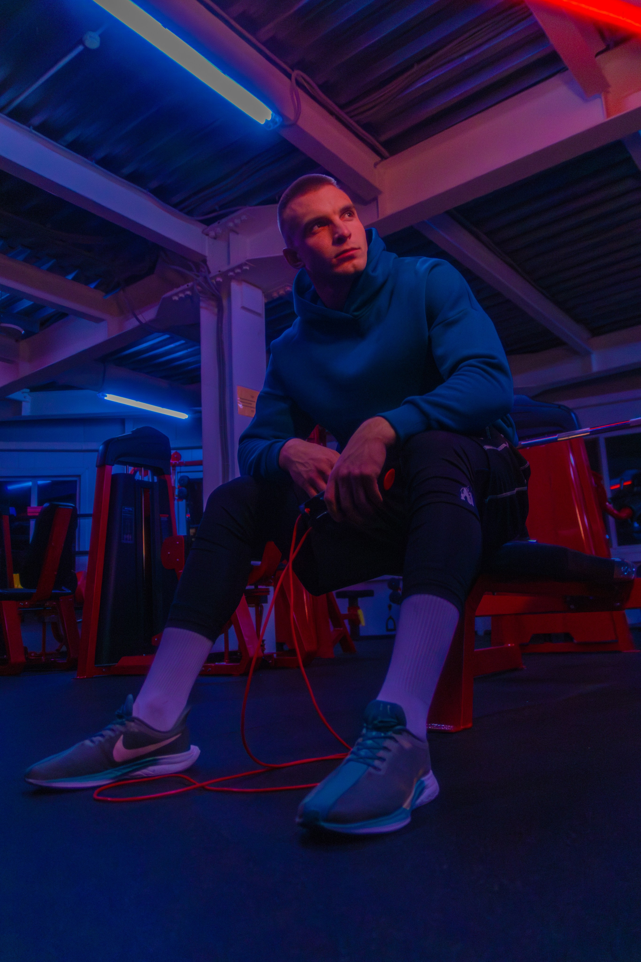 Эффектная фотография тренера в современном зале, передающая силу и харизму.