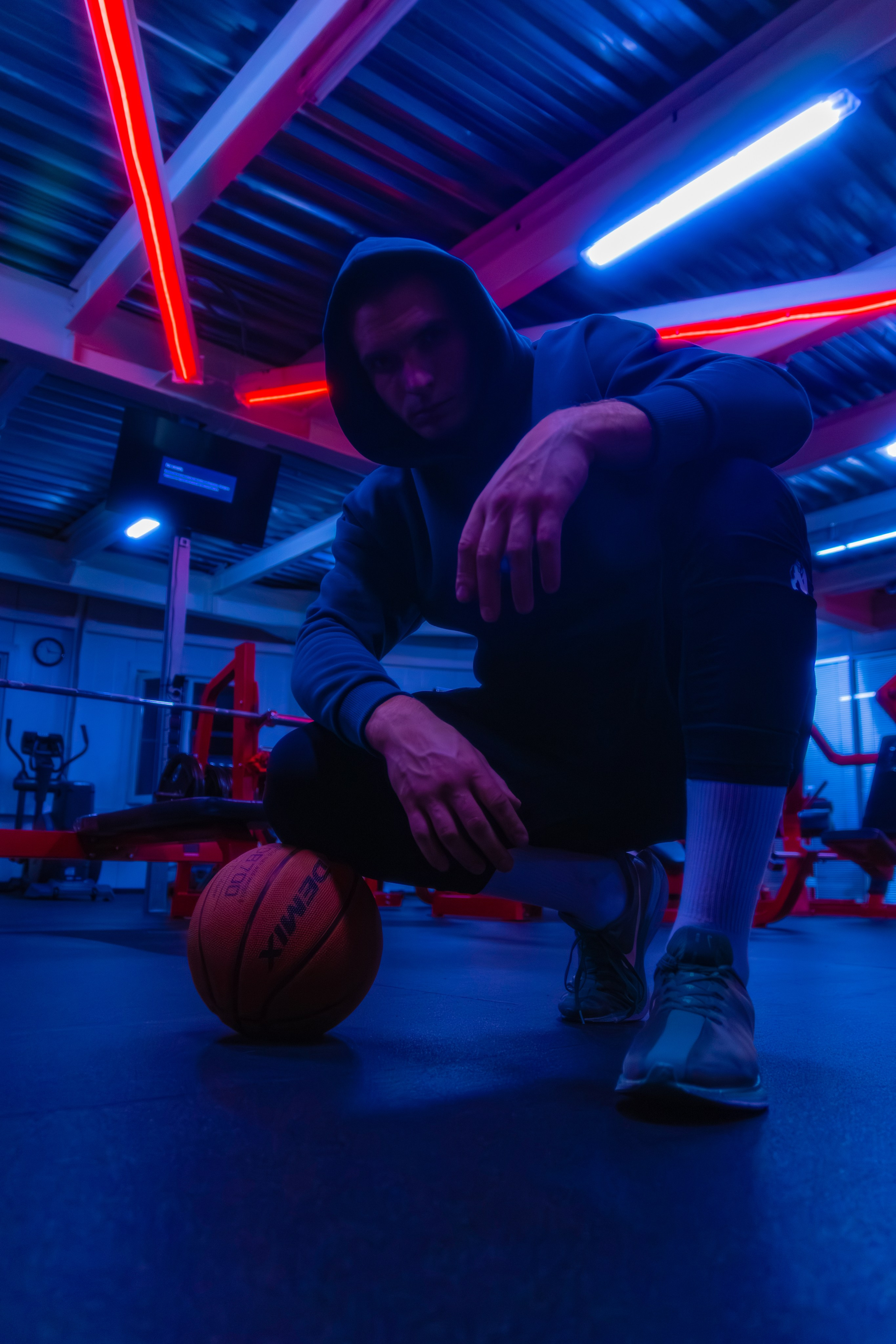 Модный кадр фитнес-профессионала в ночном клубе спорта, где каждый мускул выглядит как произведение искусства под цветным освещением.