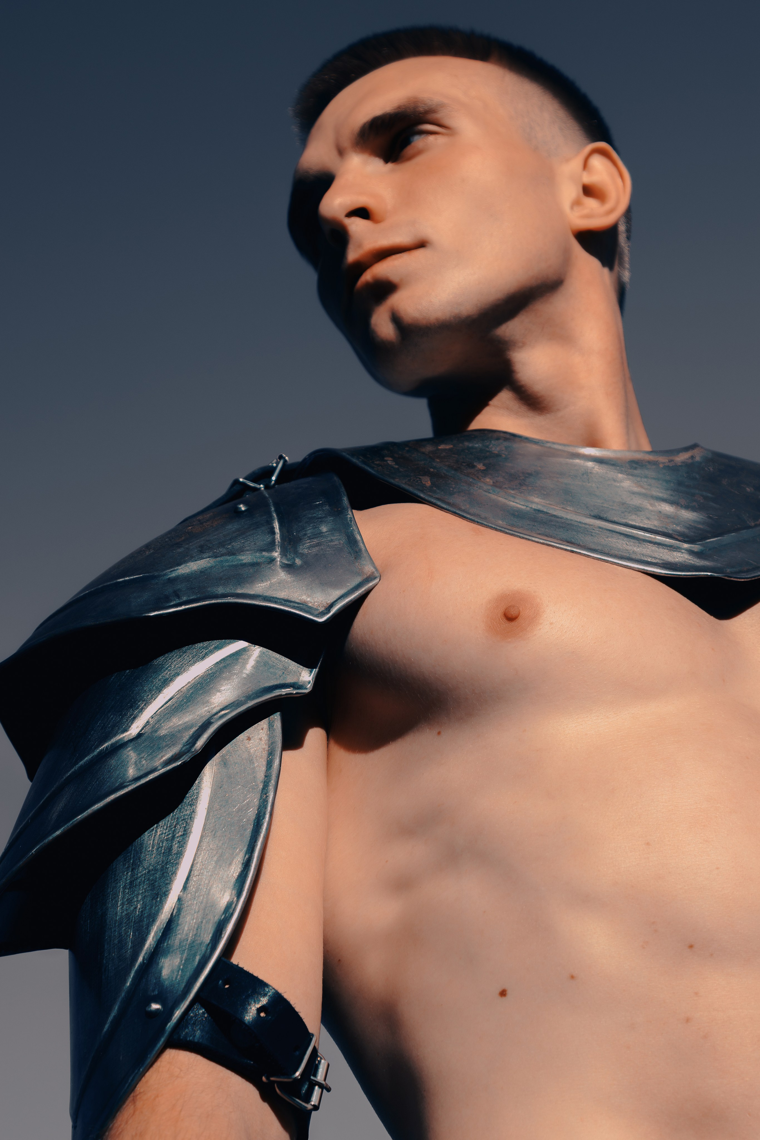 Портрет крупным планом с акцентом на мужские доспехи и грудь