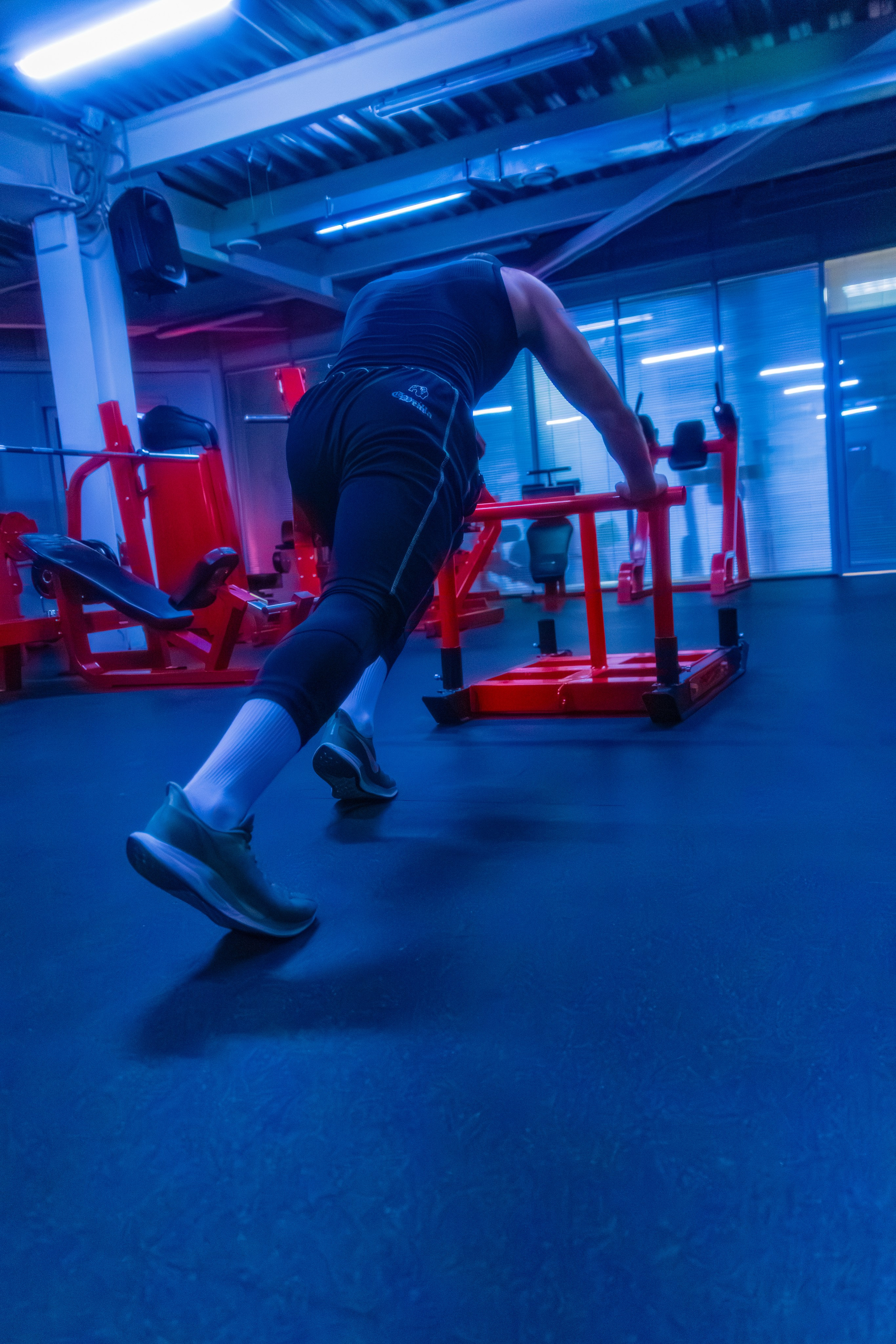 Стильный снимок фитнес-профессионала, где неоновые огни создают гламурный образ.