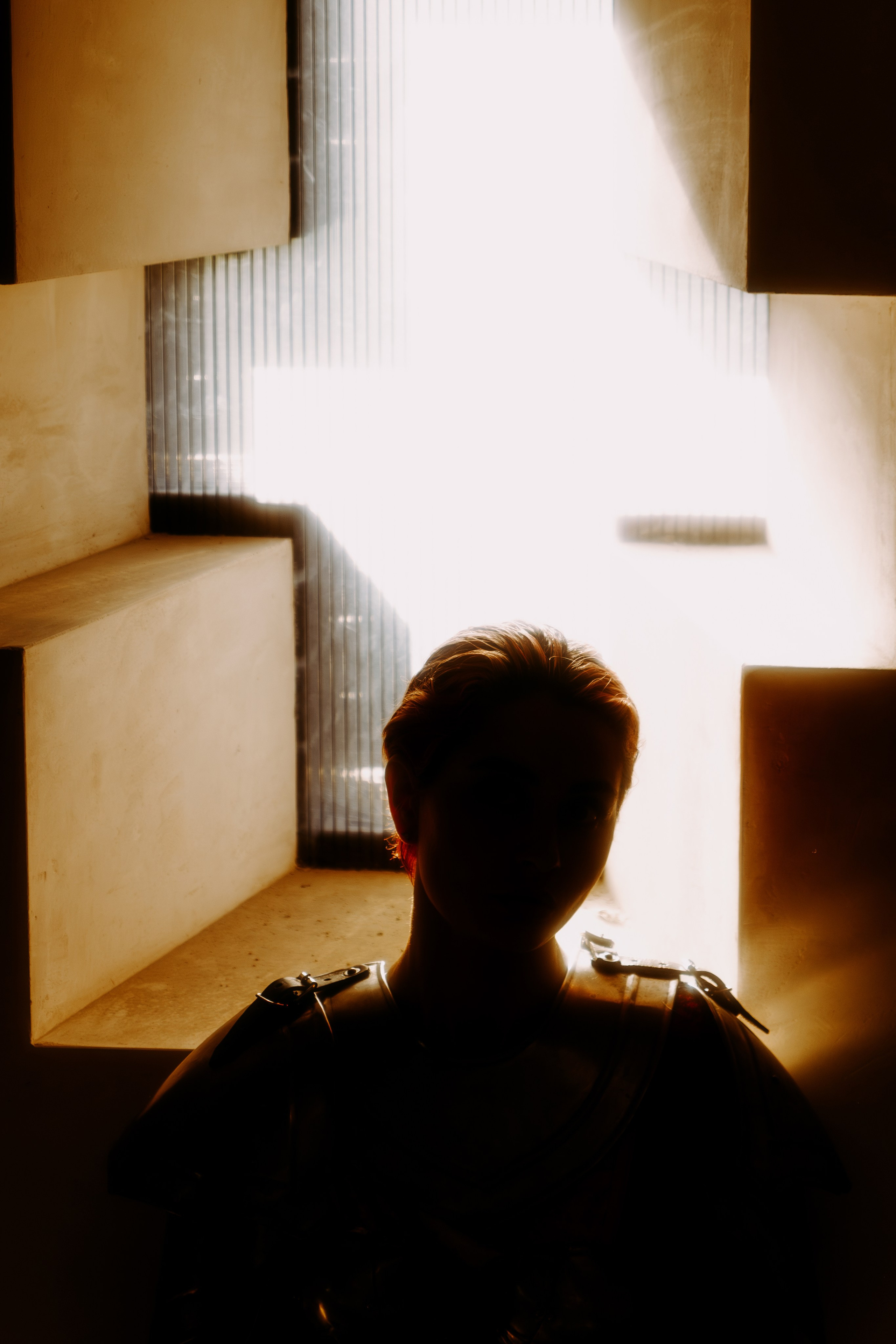 Игра теней, чёрный силуэт на фоне которого крест в виде окна