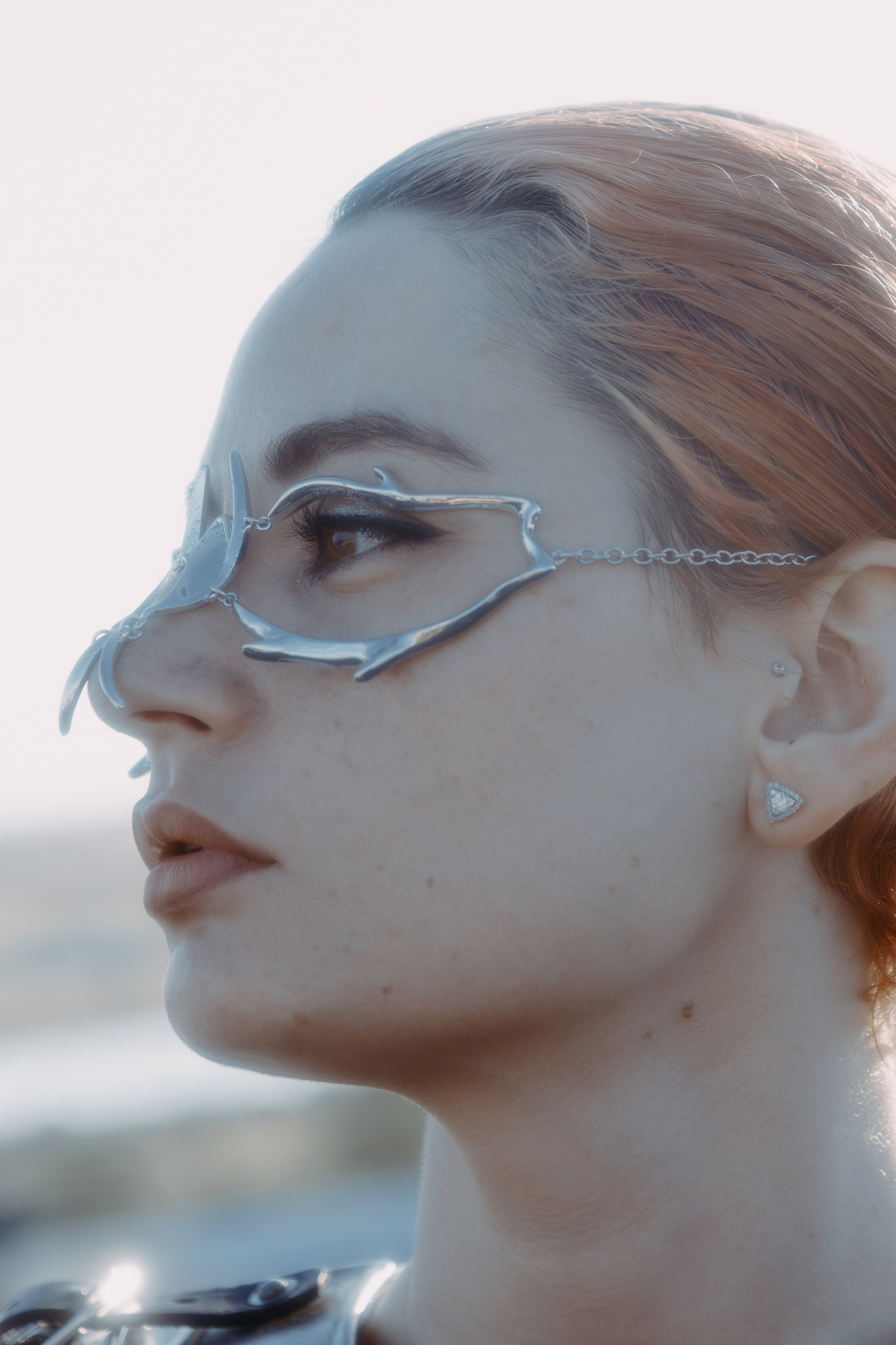 Портрет в профиль красноволосой девушки с украшеньями на лице