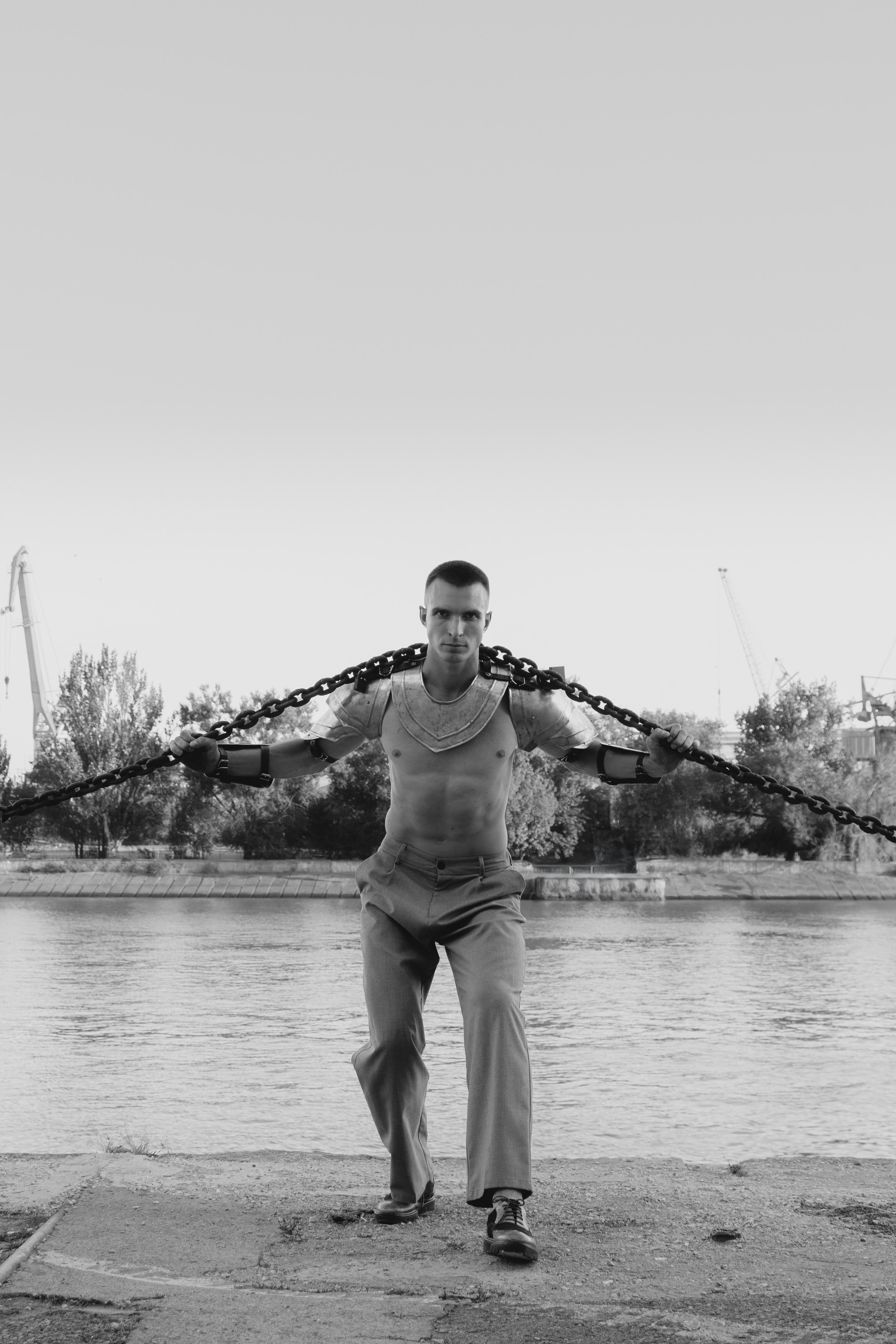 Чёрно белая фотография мужчины с большой цепью на своих плечах