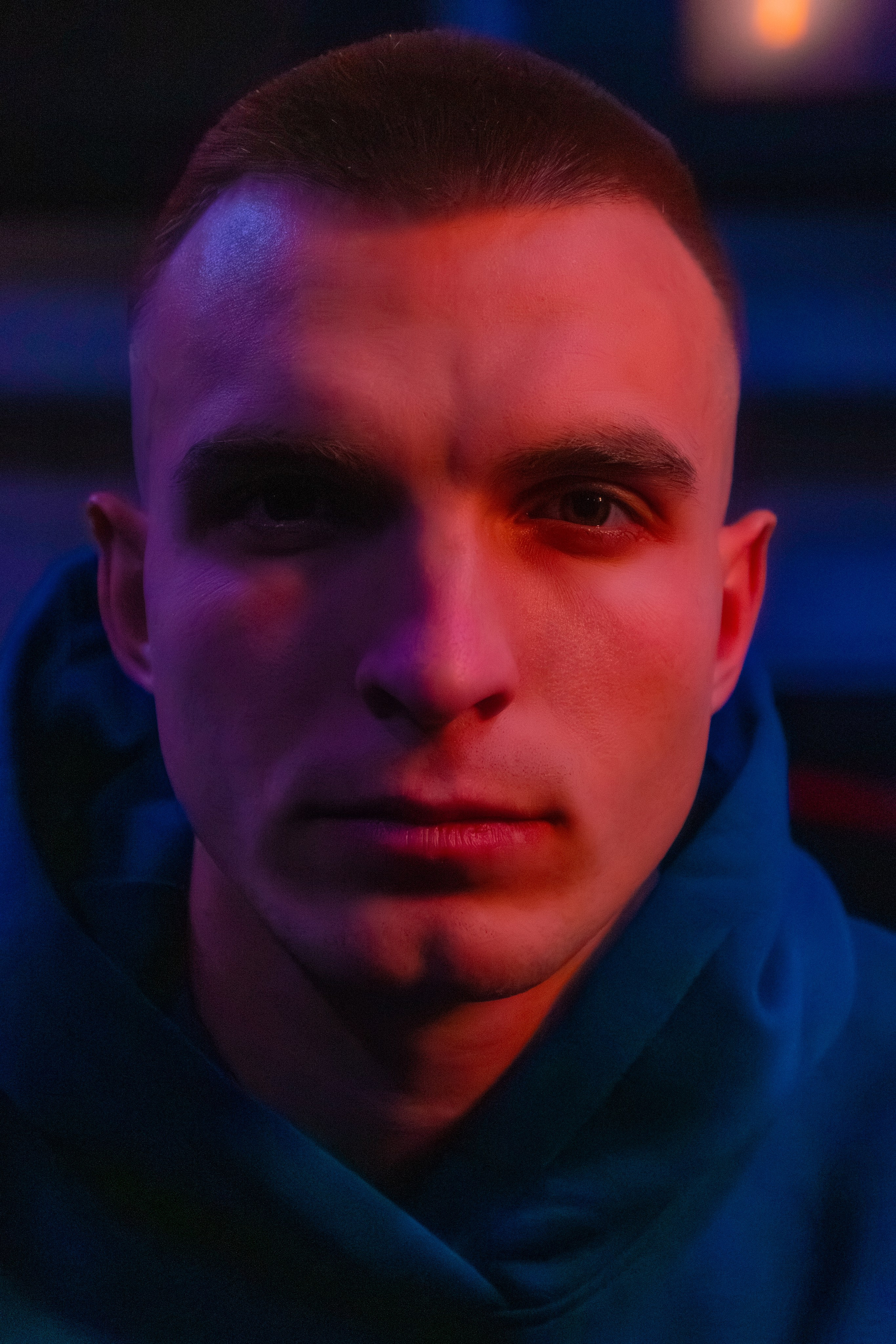 Элегантная съемка мускулистого инструктора в стильном неоновом освещении.