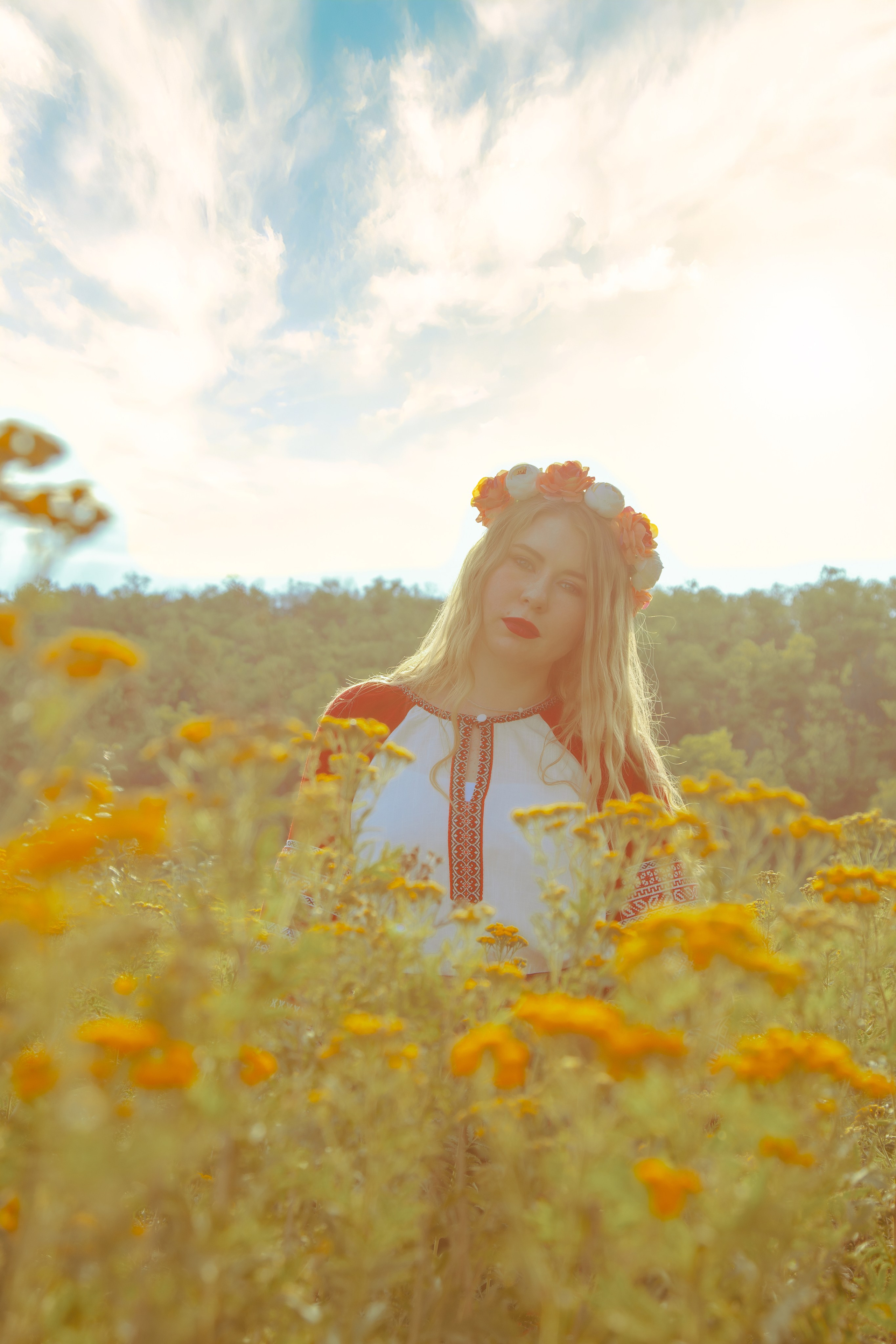 Портрет девушки в славянском платье возле жёлтых цветов и прекрасным небом 