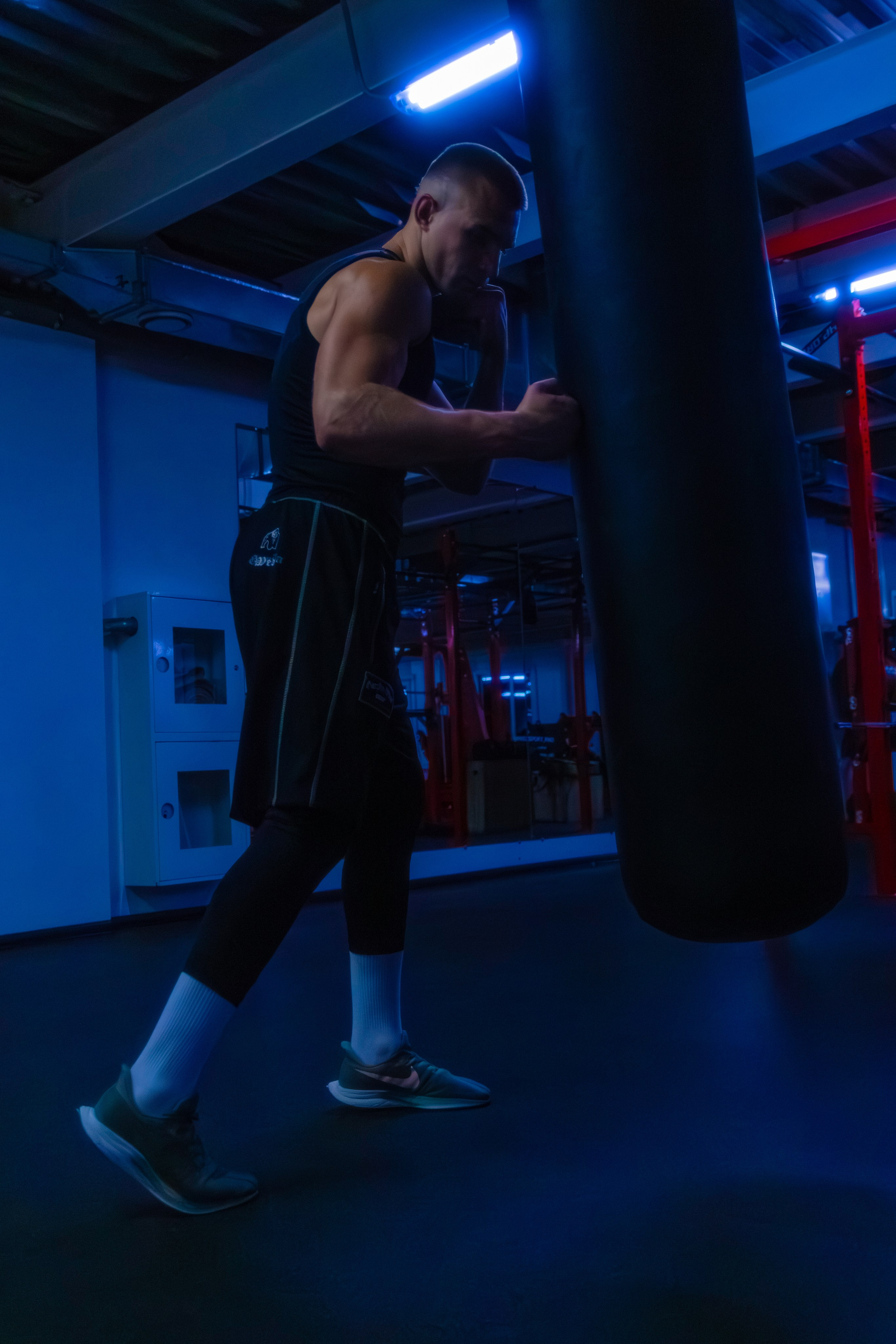 Элегантная съемка фитнес-тренера, где неоновые огни создают гламурный образ.