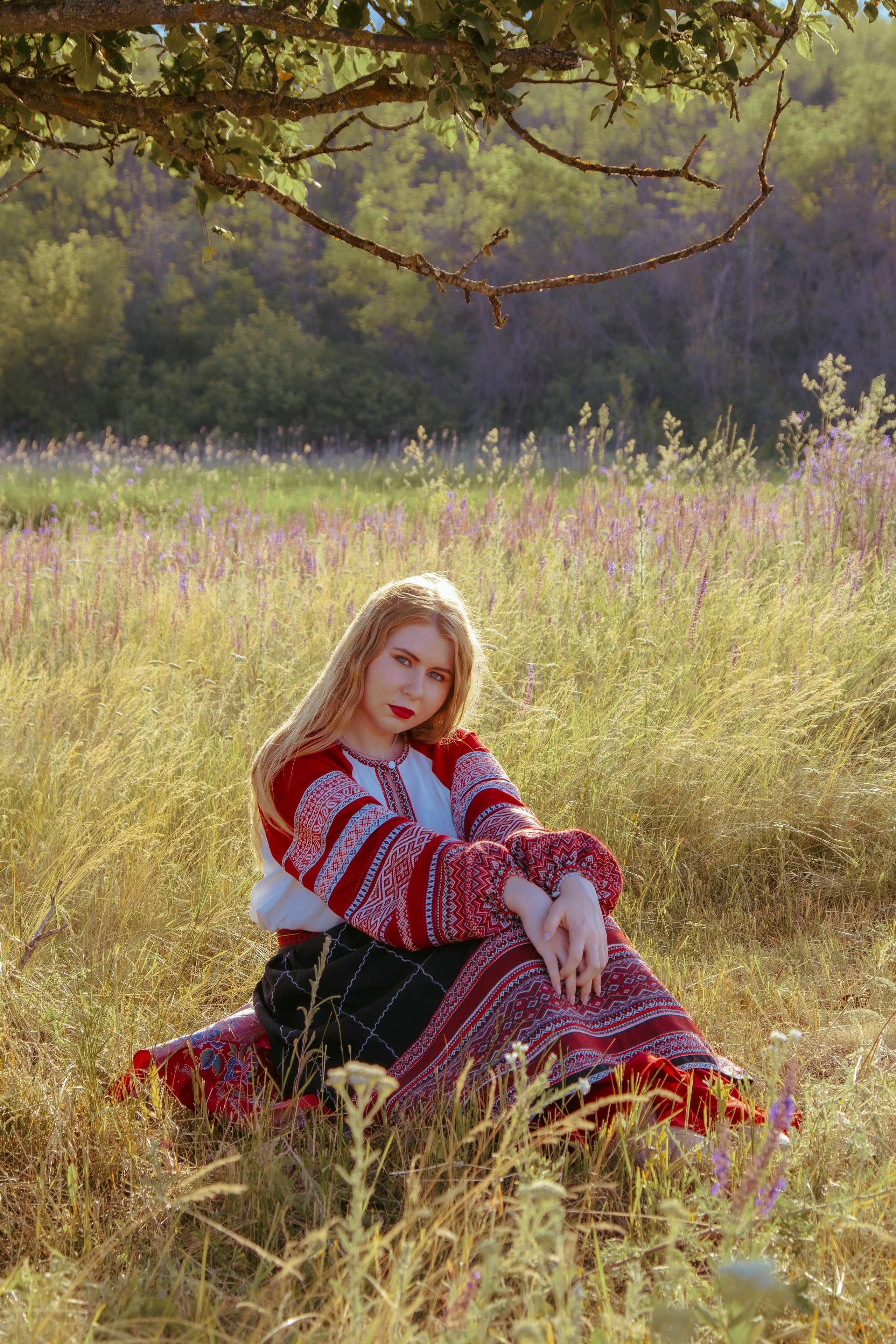 портрет девушки в русско-народной одежде в поле на фоне леса