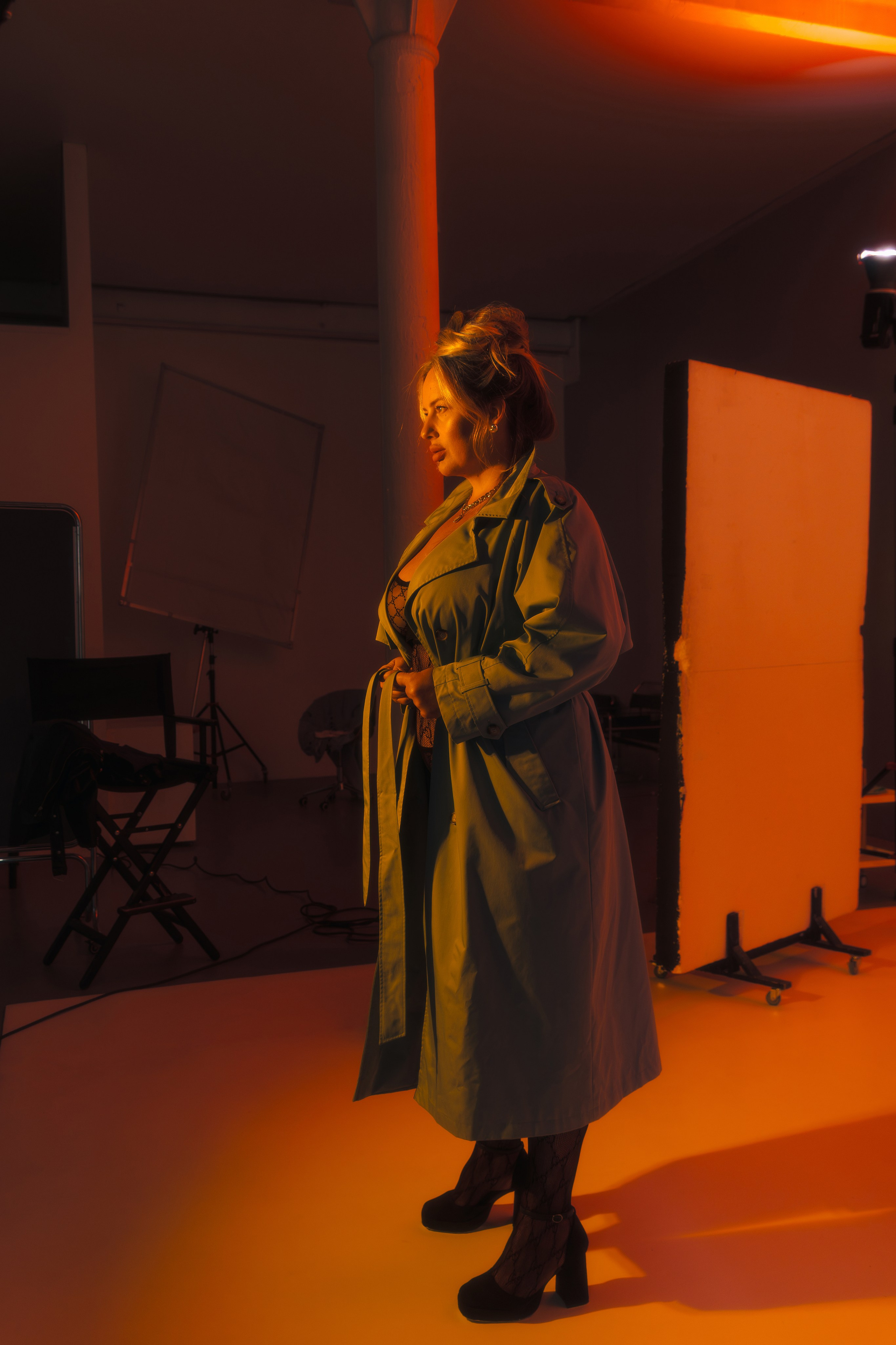 Фотография в полный рост модели плюс сайз в плаще и нижнем белье